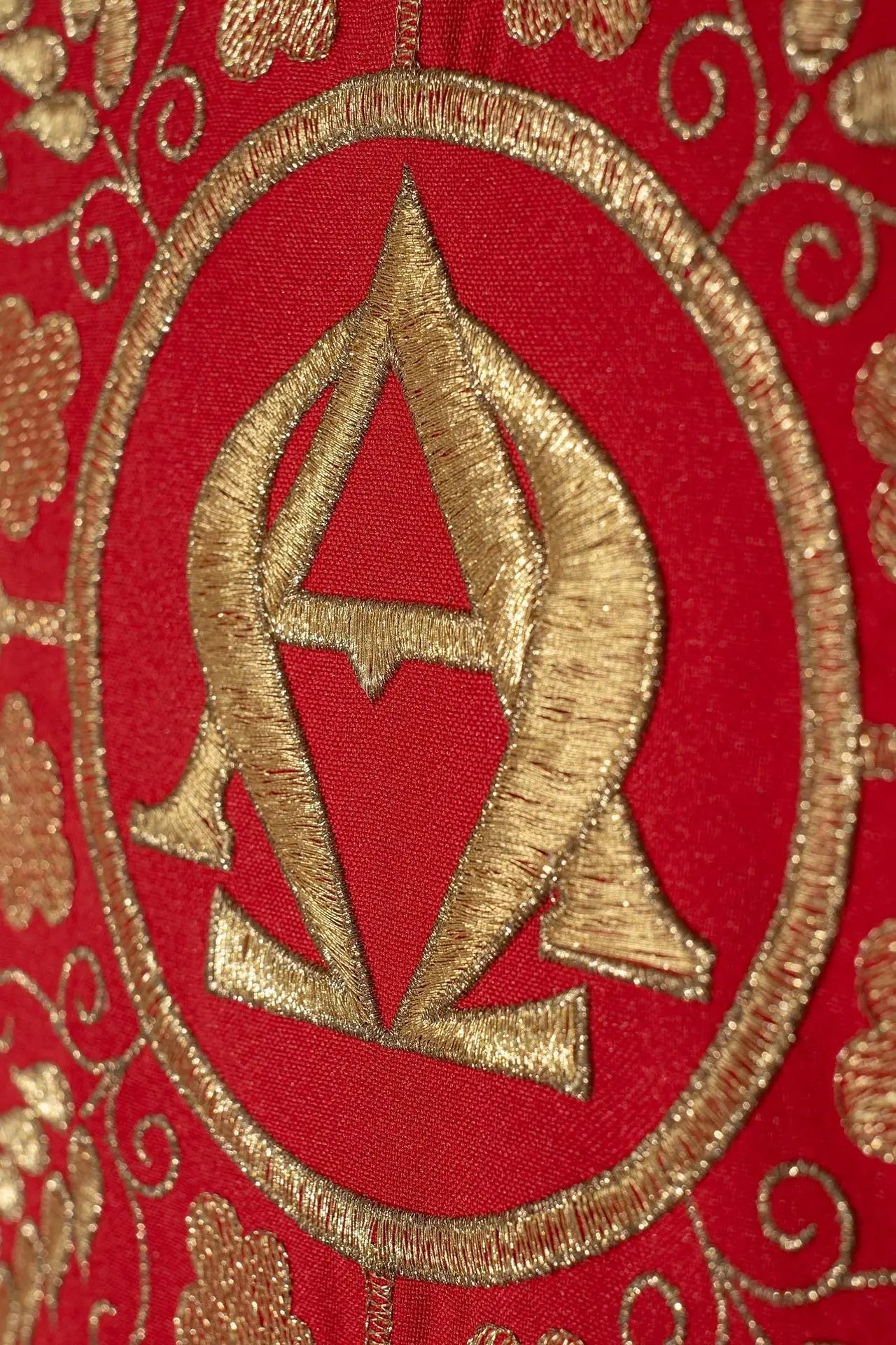 Chasuble rouge brodée avec les symboles Alpha et Omega et des épis de blé