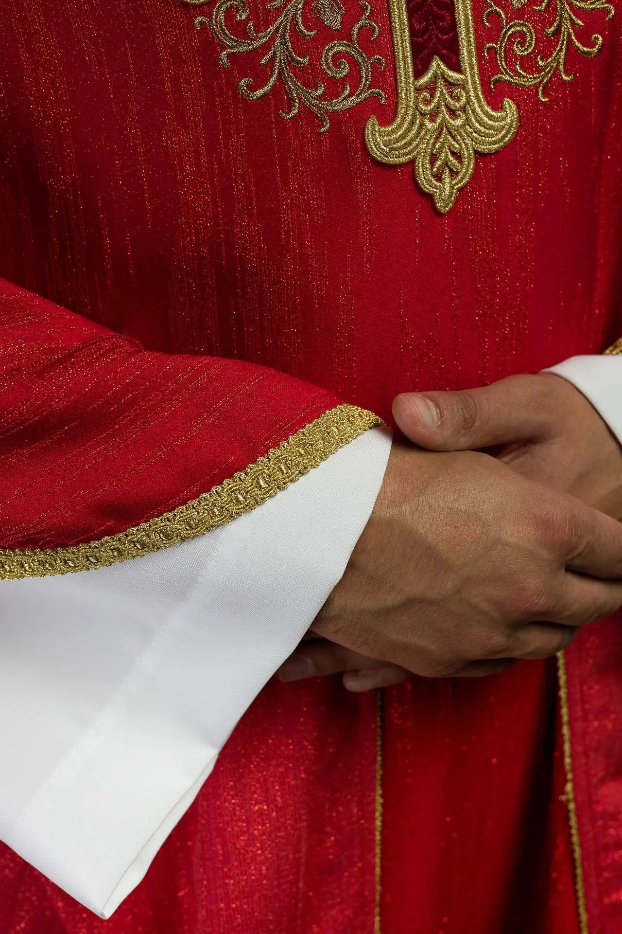 Red chasuble with embroidered cross motif on decorative fabric