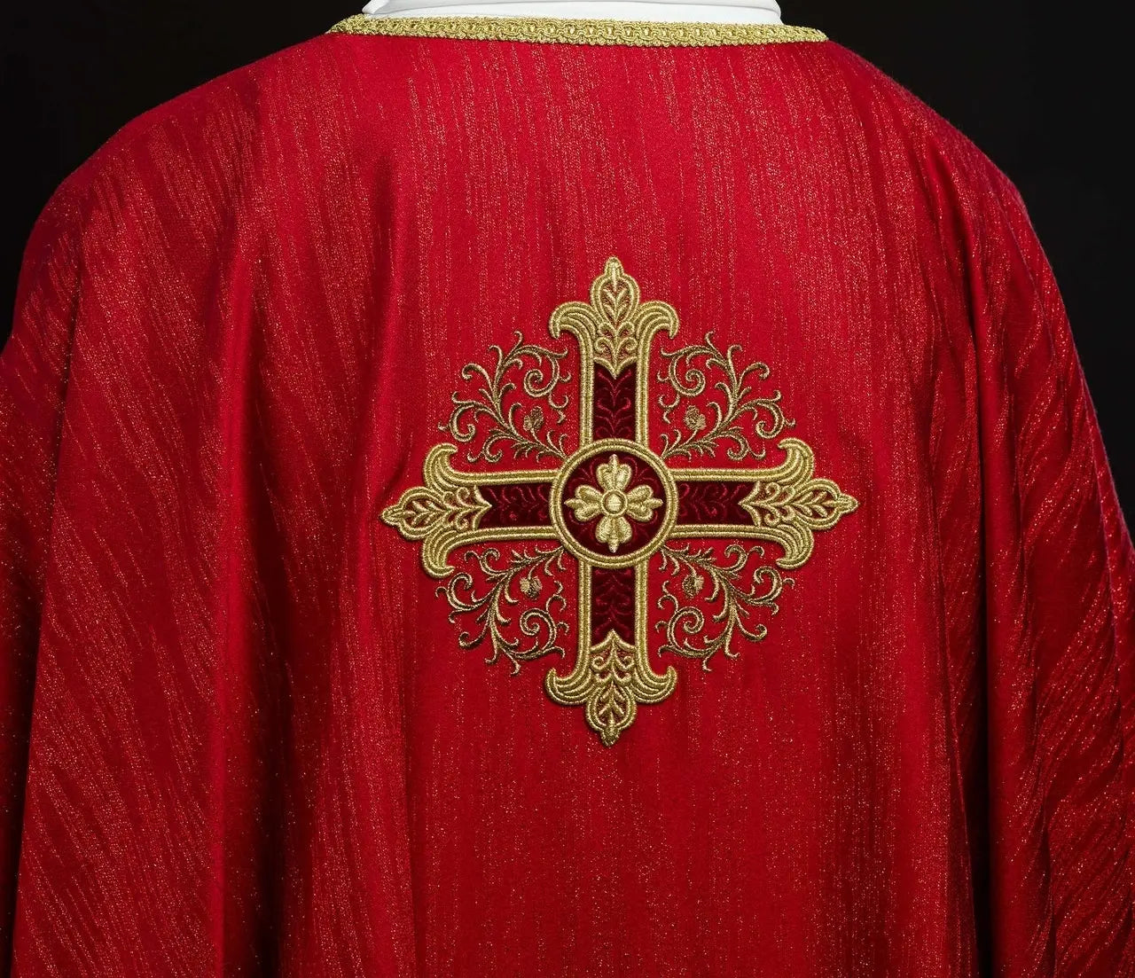 Red chasuble with embroidered cross motif on decorative fabric