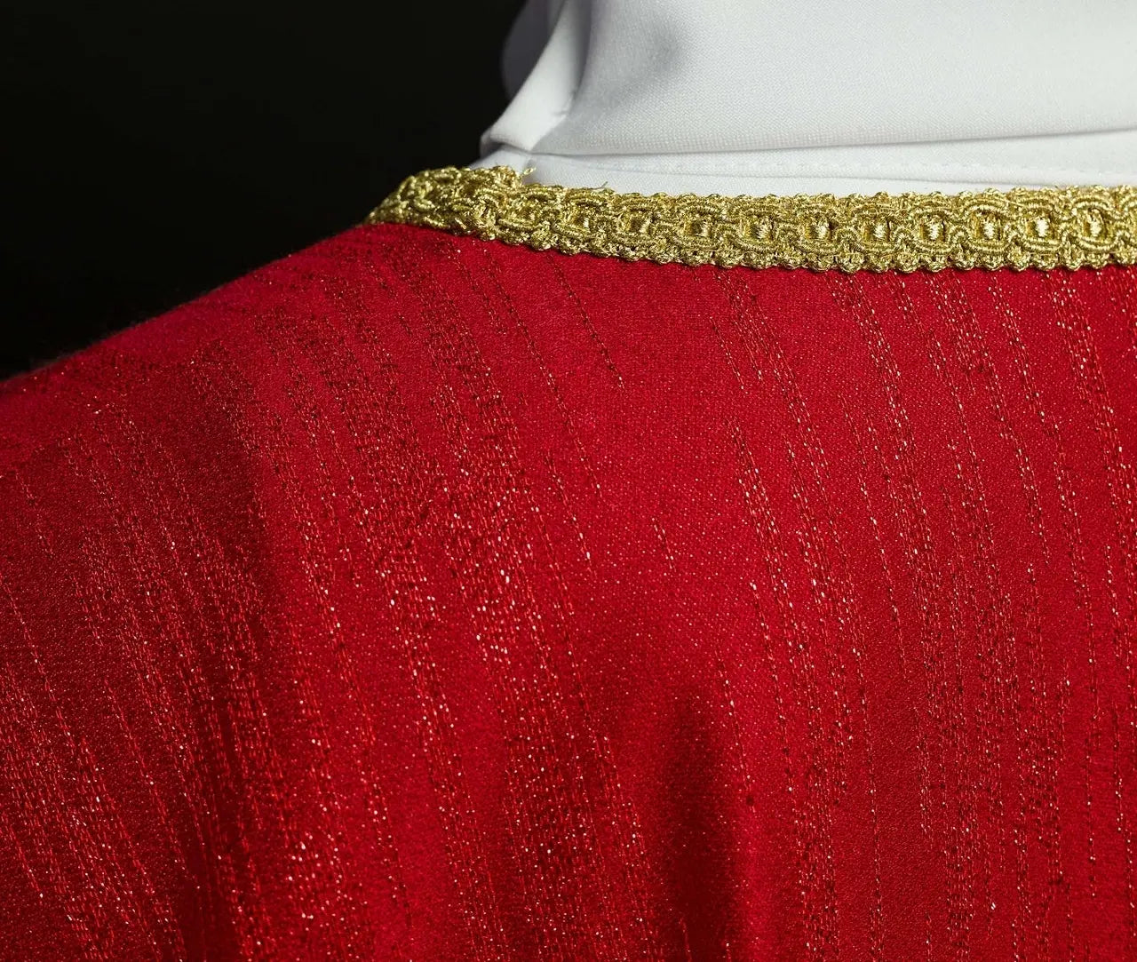 Red chasuble with embroidered cross motif on decorative fabric