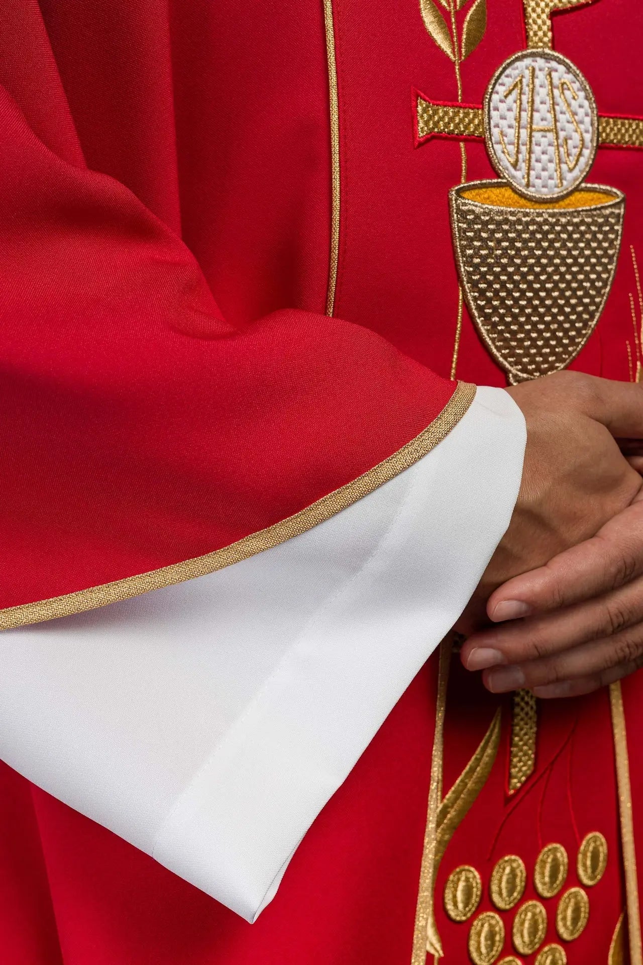 Red chasuble embroidered with IHS chalice design