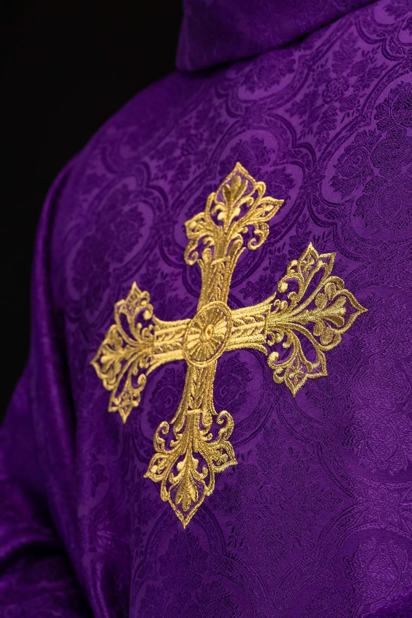 Purple chasuble with a gold embroidered cross on jacquard fabric, featuring a stand-up collar and gold trim.