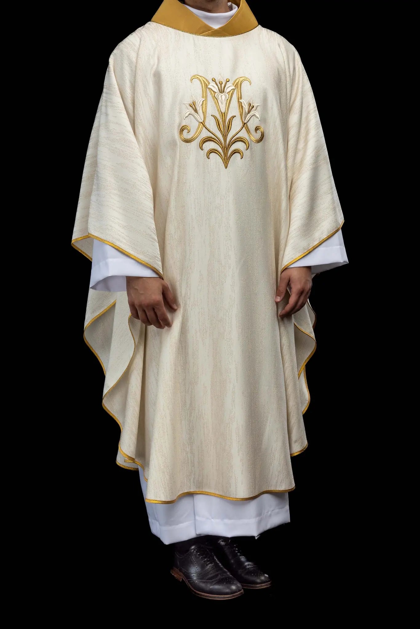 Ecru chasuble with Marian lily embroidery, gold collar, and gold trim.