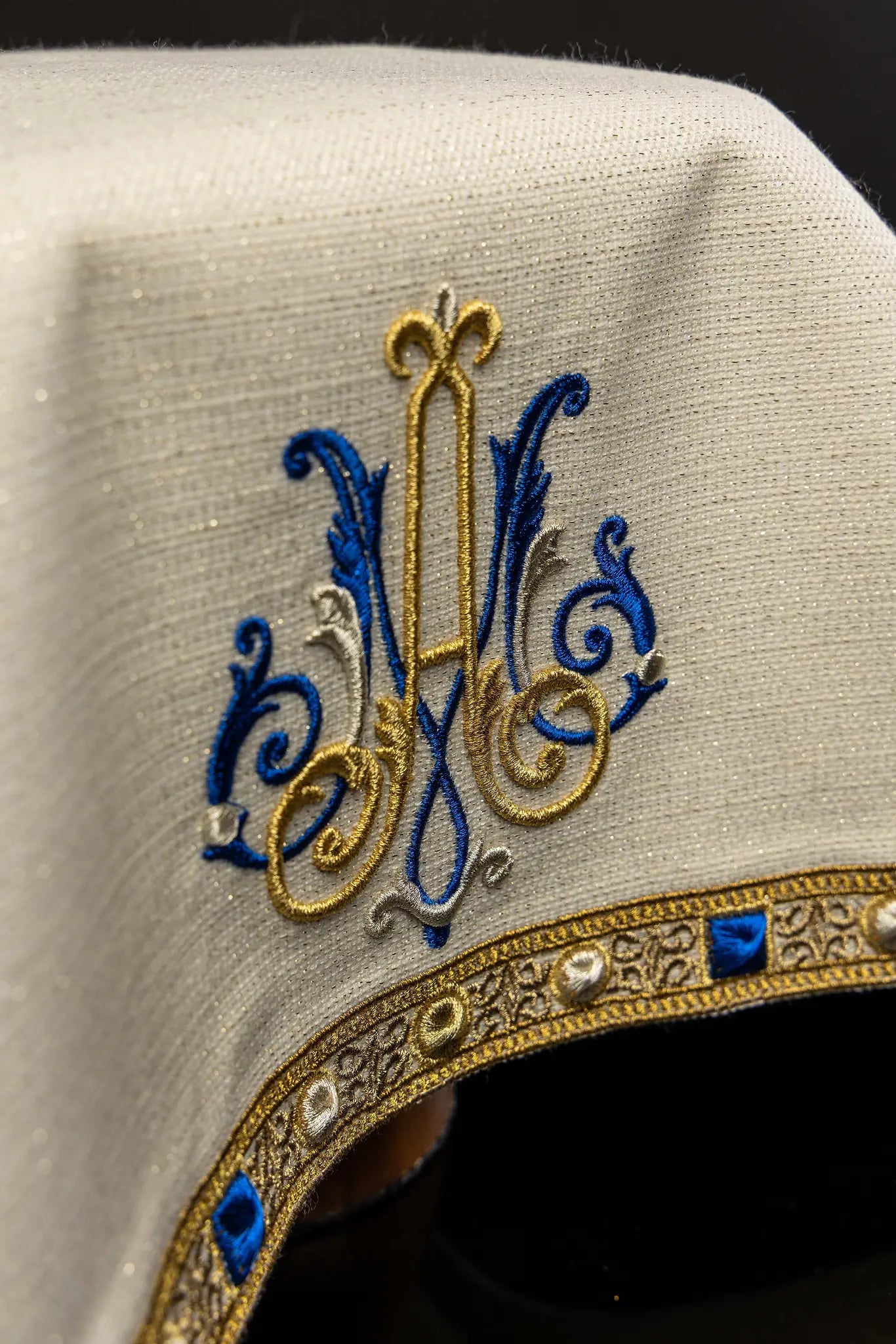 Ecru chalice veil with Marian embroidery in gold, blue, and silver, featuring a decorative gold trim with blue and pearl-like details.