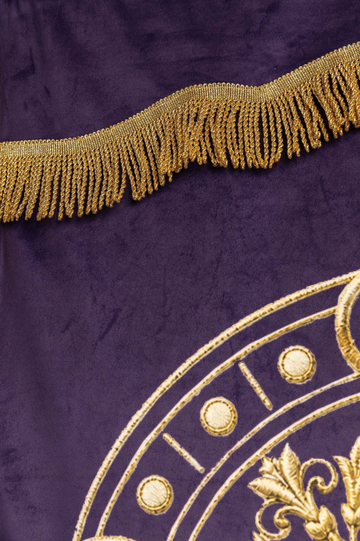 Bannière violette avec franges dorées et médaillon brodé, gros plan
