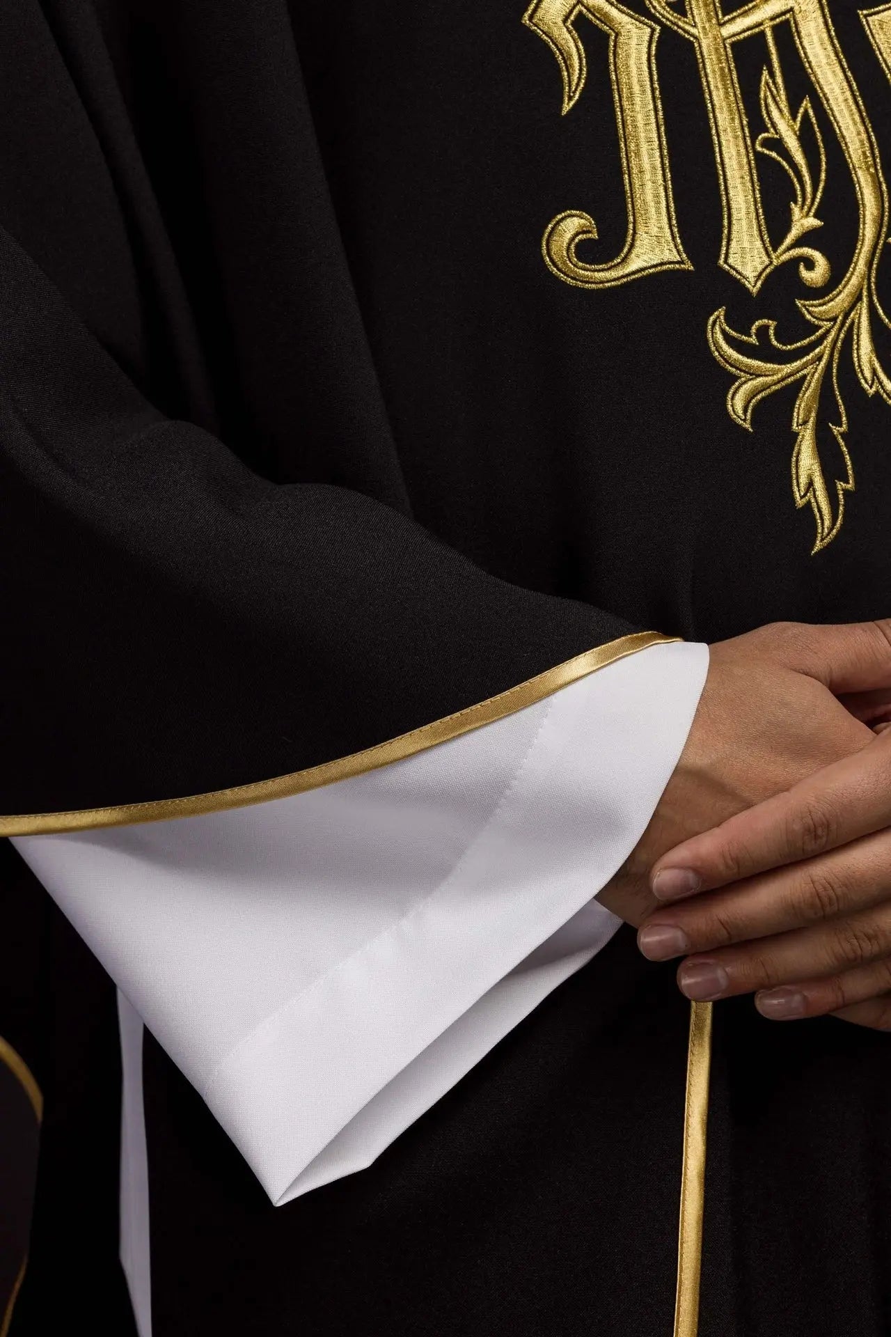 Black chasuble embroidered with IHS