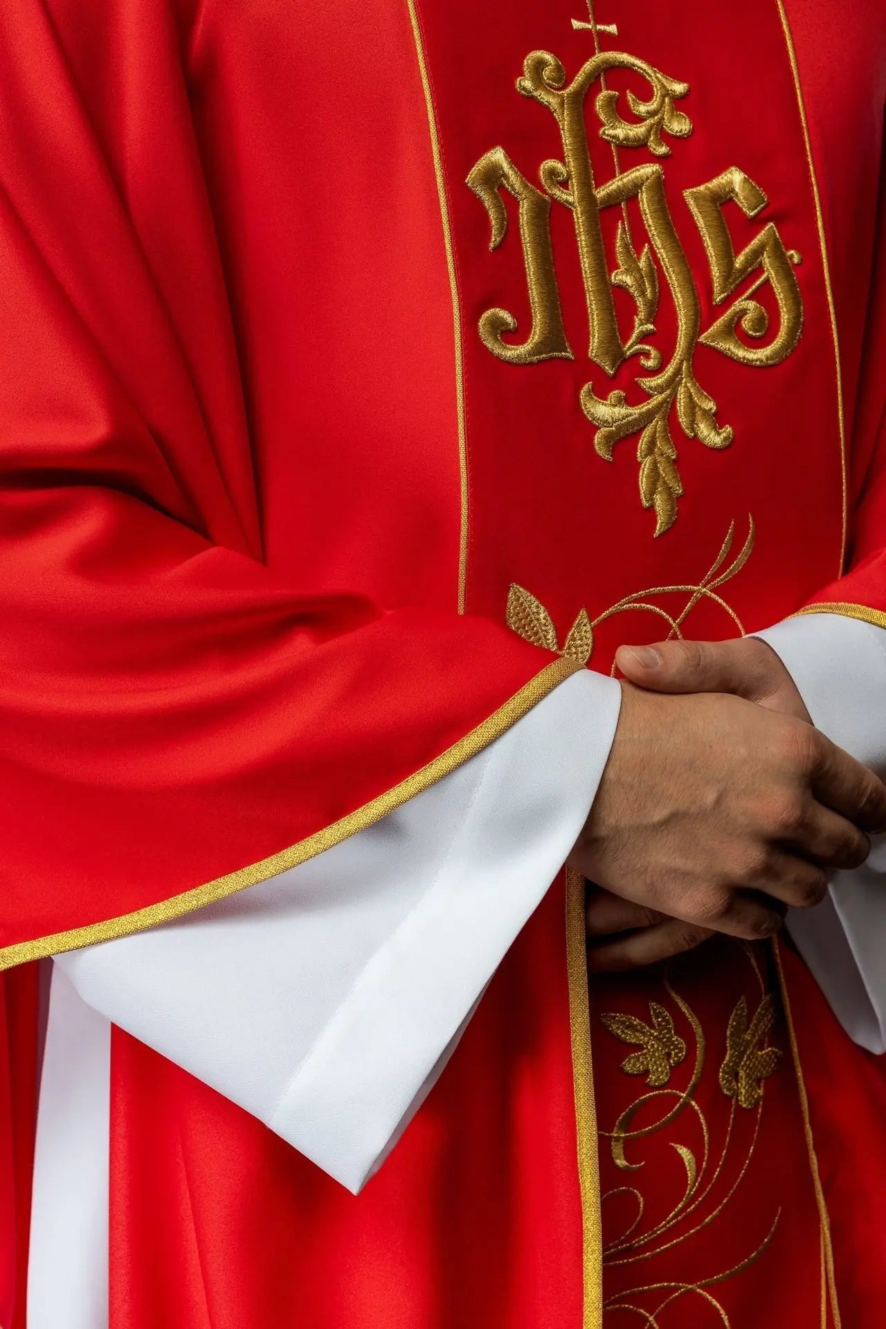 Red liturgical chasuble with richly decorated belt with floral motif and IHS