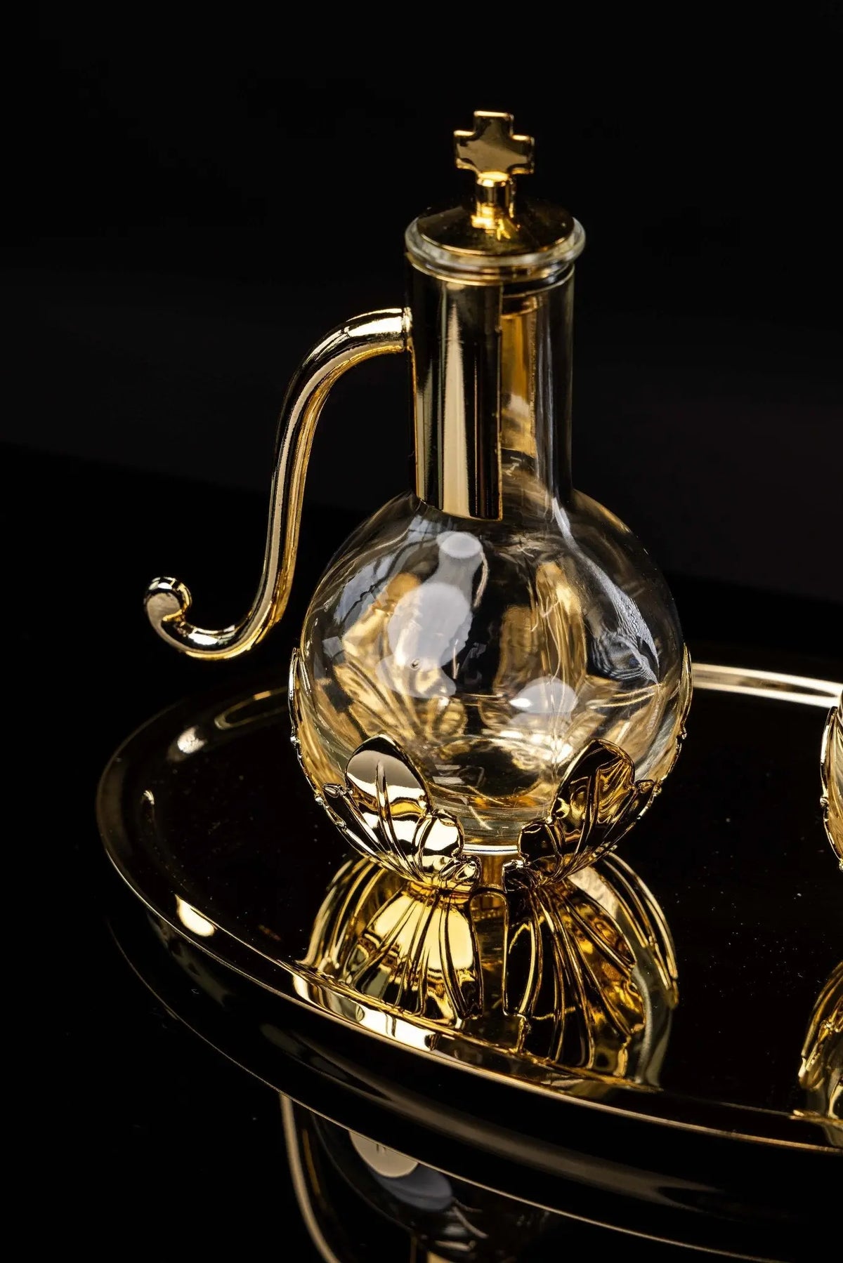 Dorée, burette liturgique avec croix et feuilles, gros plan de trois quarts