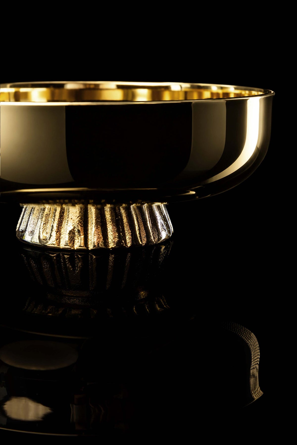 Gold-plated paten with fluted base, close-up side view