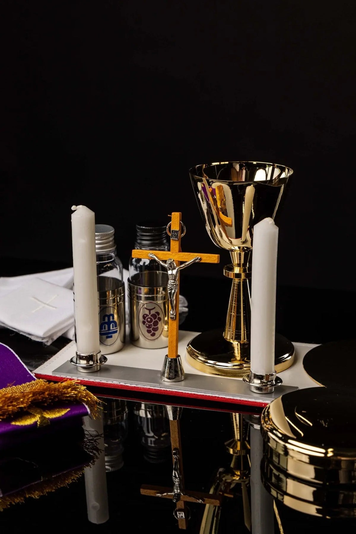 Valise de mission noire avec équipement liturgique, vue rapprochée de l'étole violette et des linges de calice