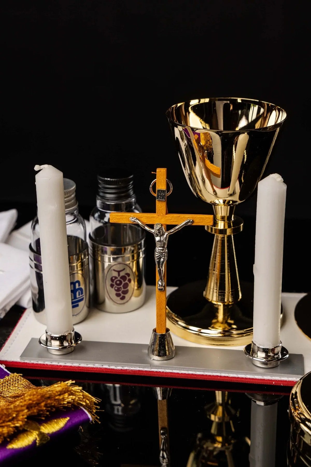 Valise de mission noire avec équipement liturgique, gros plan sur la croix et les flacons