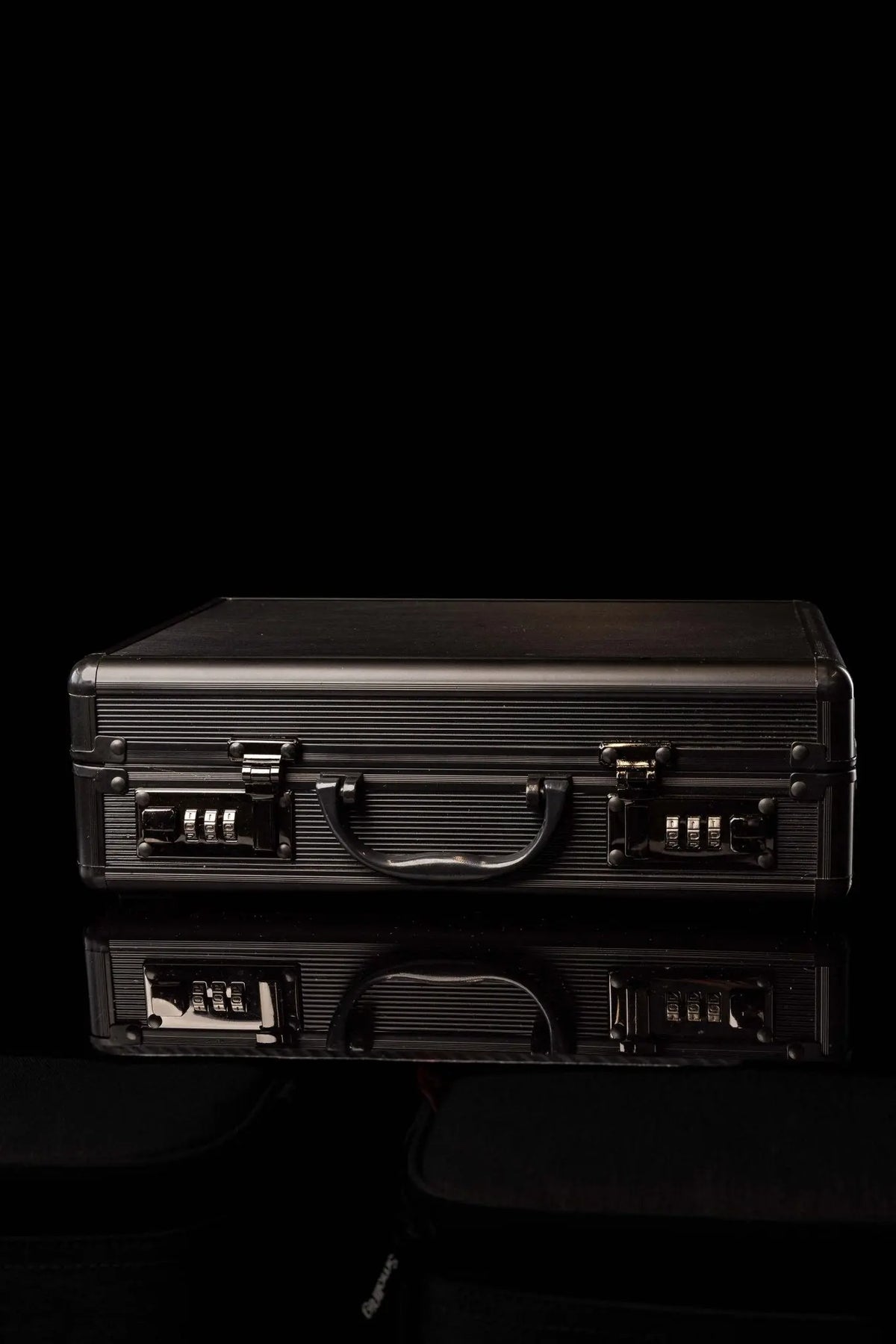 Valise noire avec équipement liturgique en aluminium, fermée avec deux serrures à combinaison, vue de face