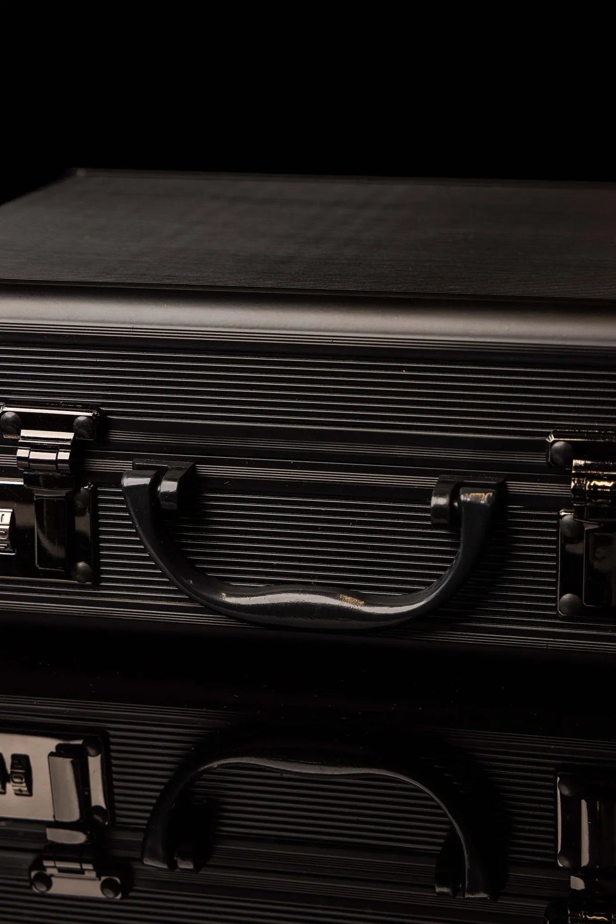 Valise noire avec équipement liturgique en aluminium, gros plan sur la poignée et les serrures