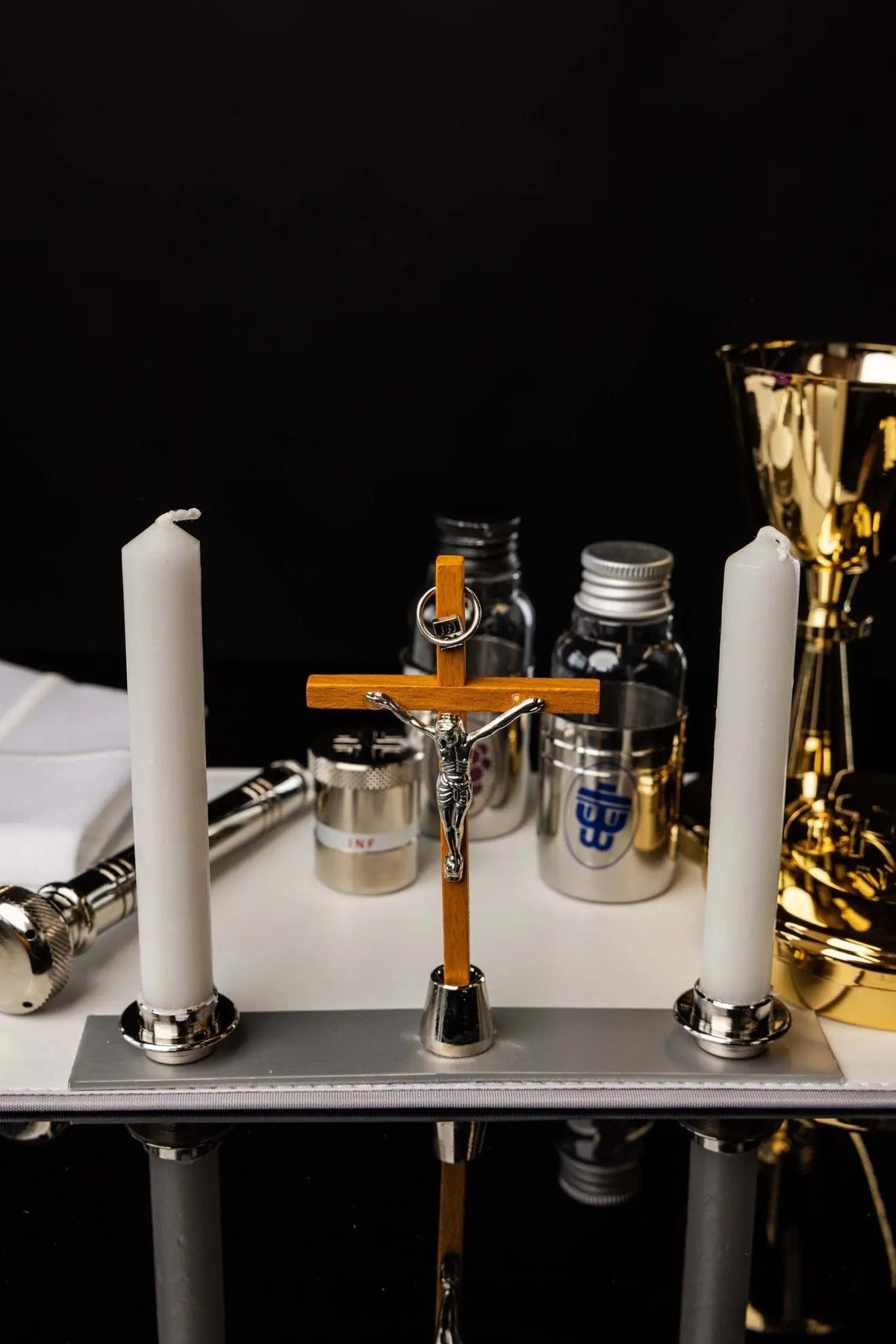 Valise liturgique ouverte avec croix, cierges et accessoires, vue de face