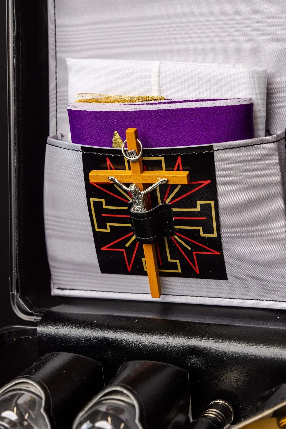 Valise liturgique, croix en bois avec Christ sur motif géométrique, gros plan