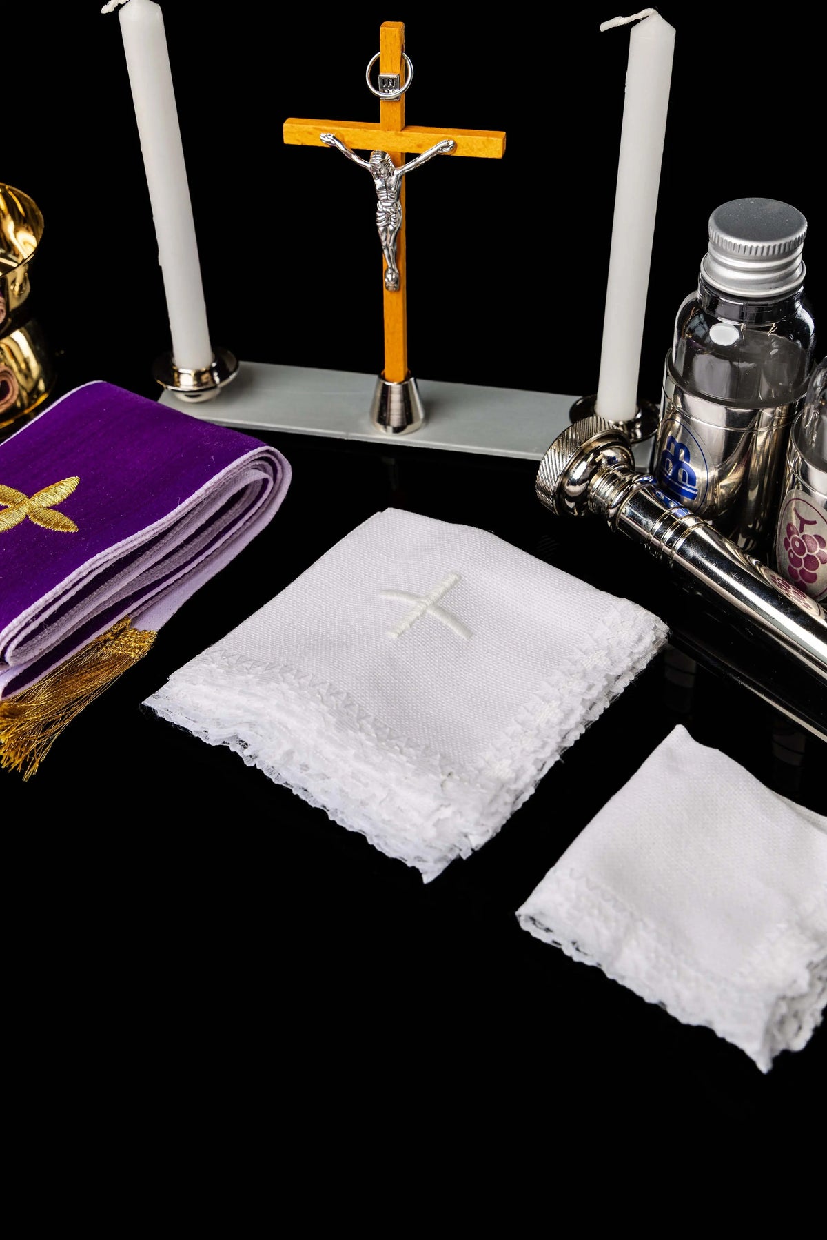 Valise liturgique de mission avec croix, bougies, étole et linges liturgiques, gros plan