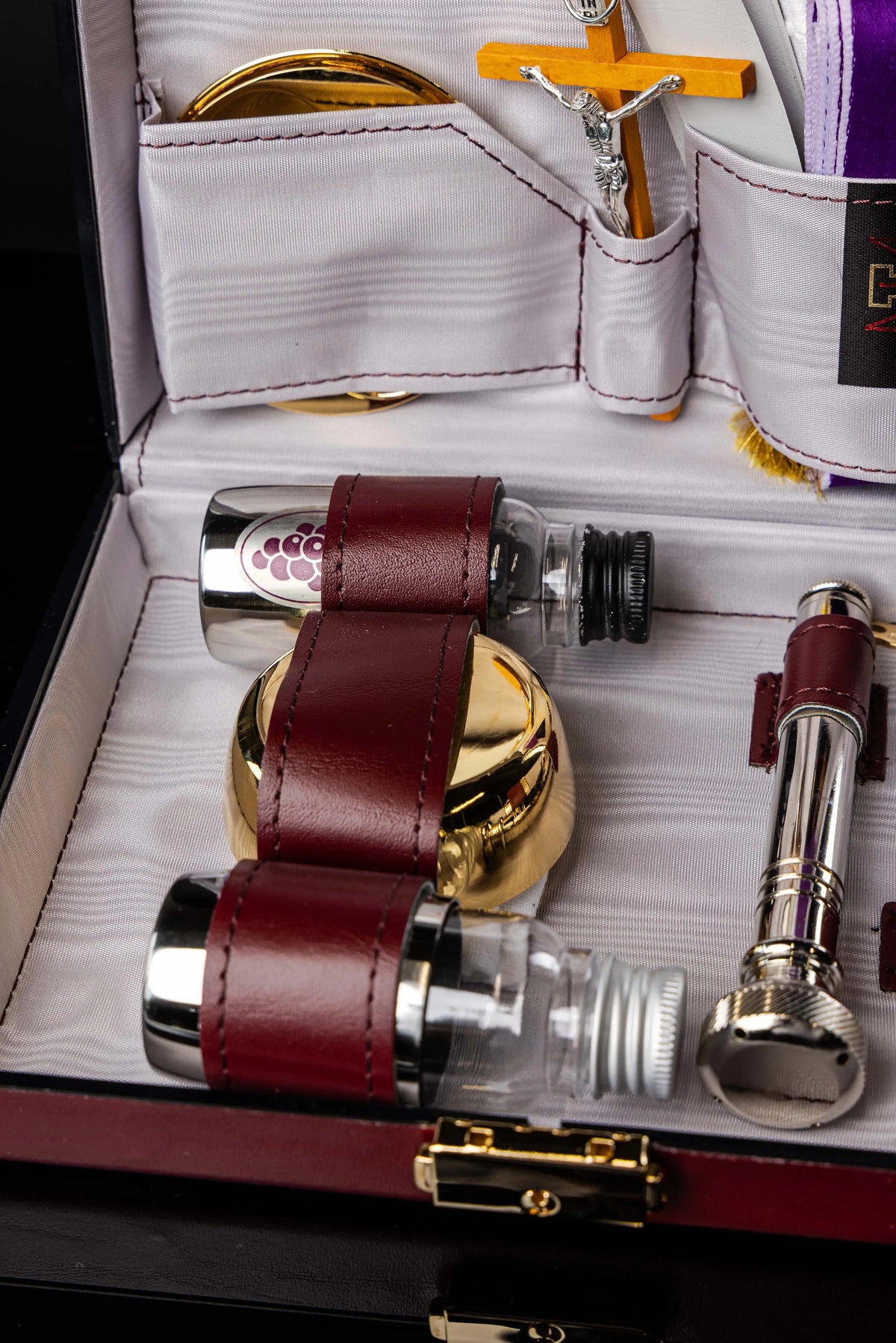 Valise liturgique de mission avec accessoires métalliques et flacons, gros plan inférieur