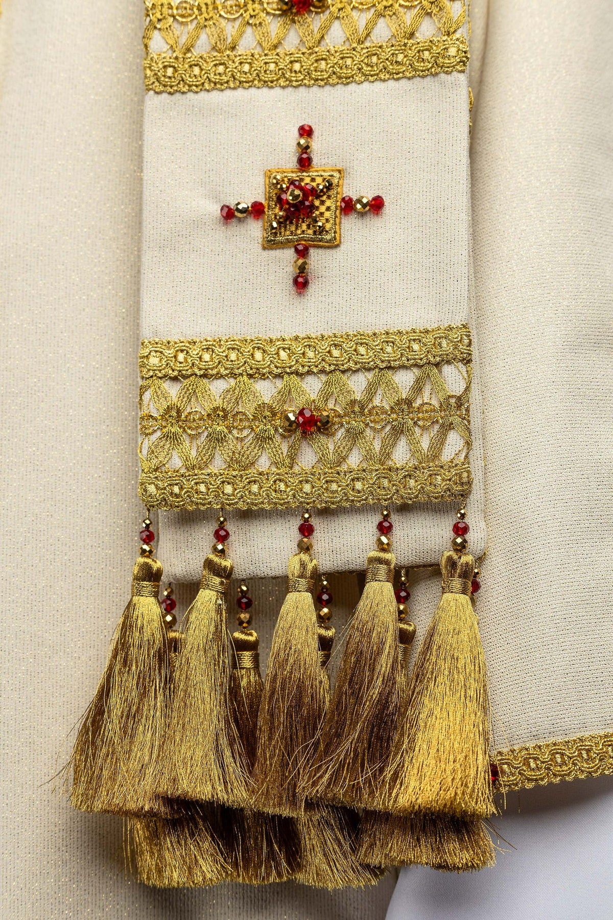 Chasuble écru ornée de pierres naturelles, détail des glands dorés