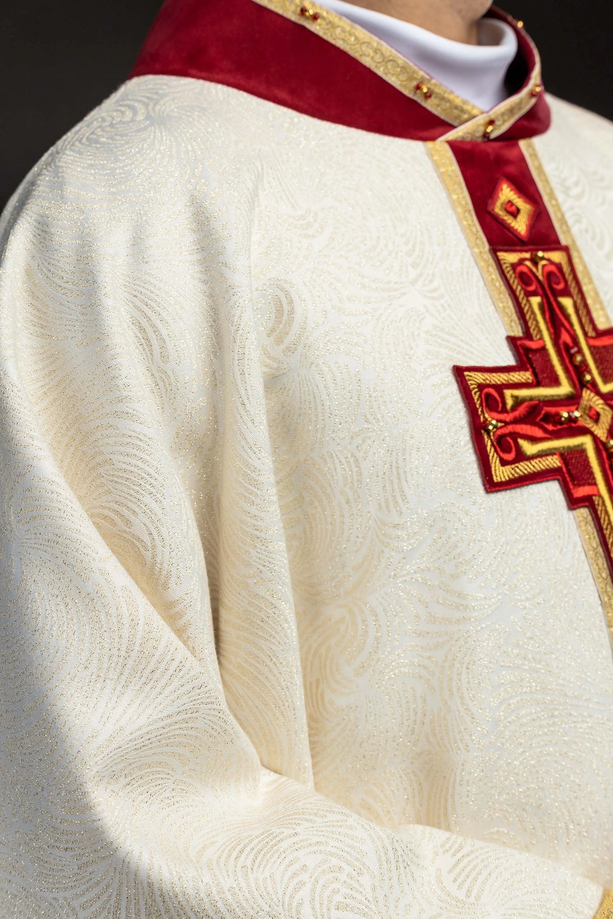 Écru chasuble avec croix brodée et pierres naturelles, gros plan sur la croix et le tissu