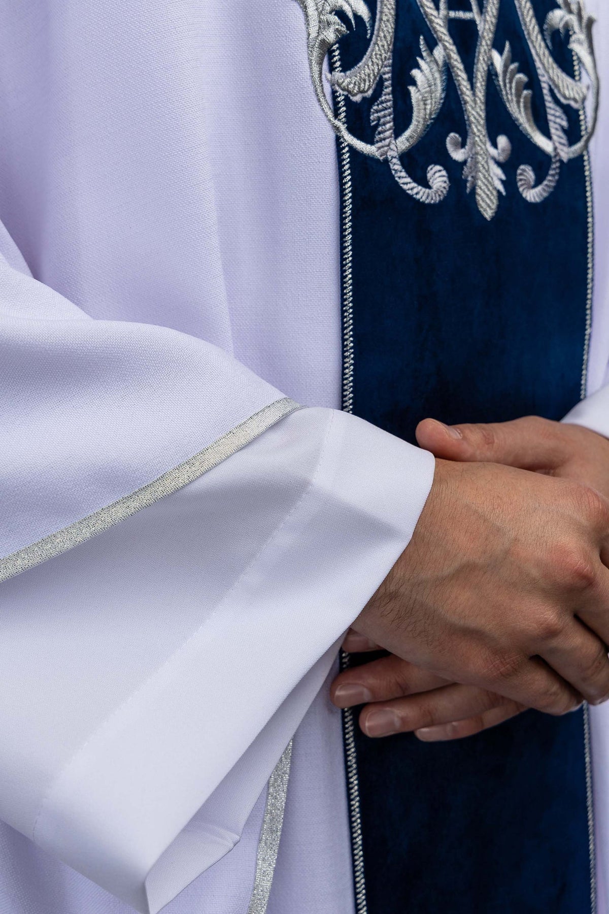 White chasuble with embroidered Marian monogram, sleeve trim close-up