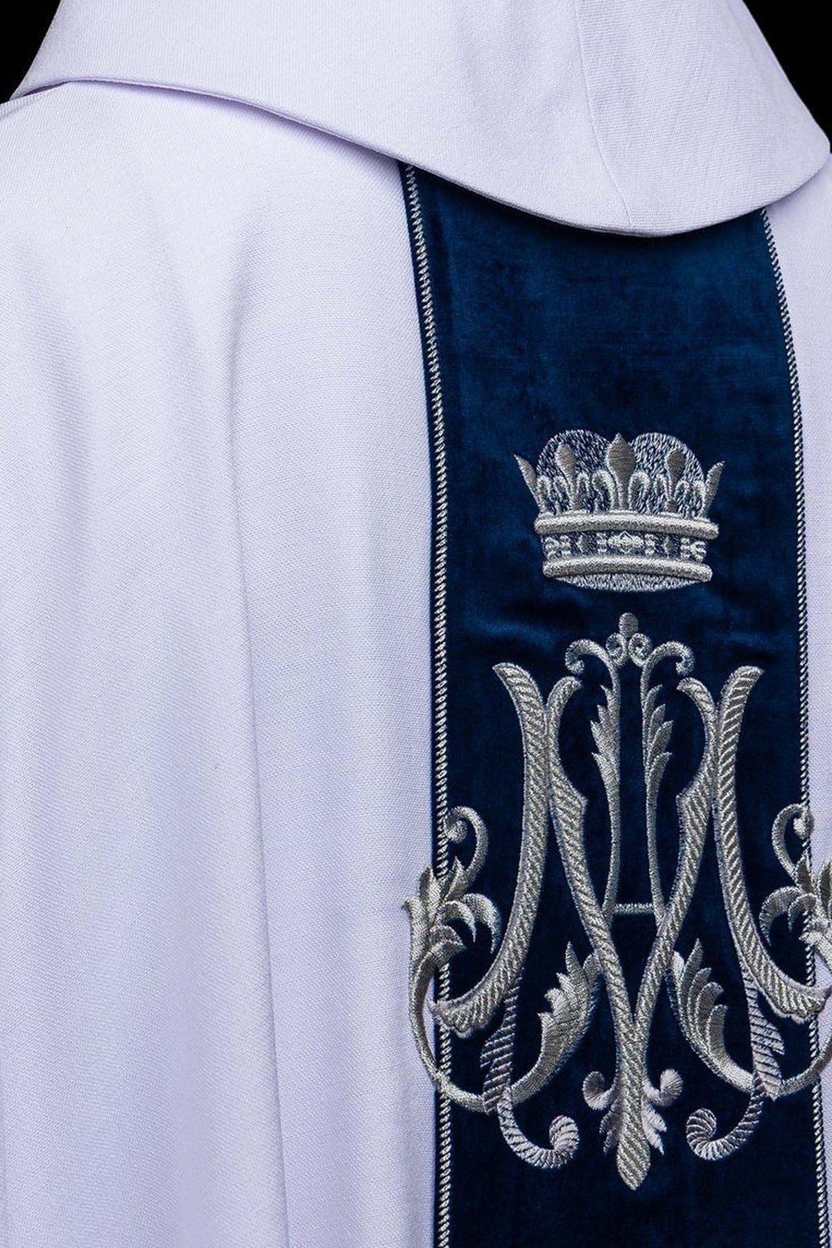 White chasuble with embroidered crowned Marian monogram, upper front view