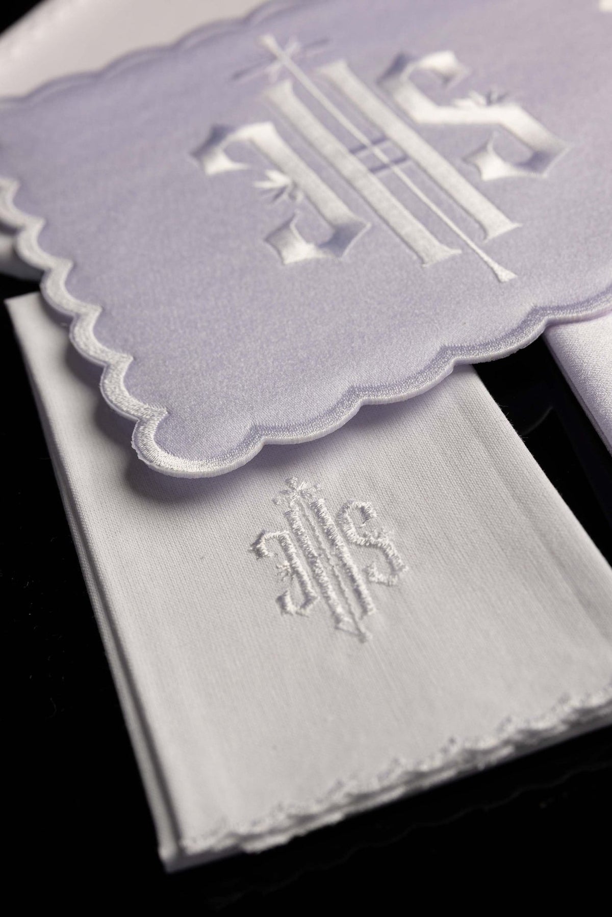 Linges de calice blancs avec monogramme IHS, détail du linge plié