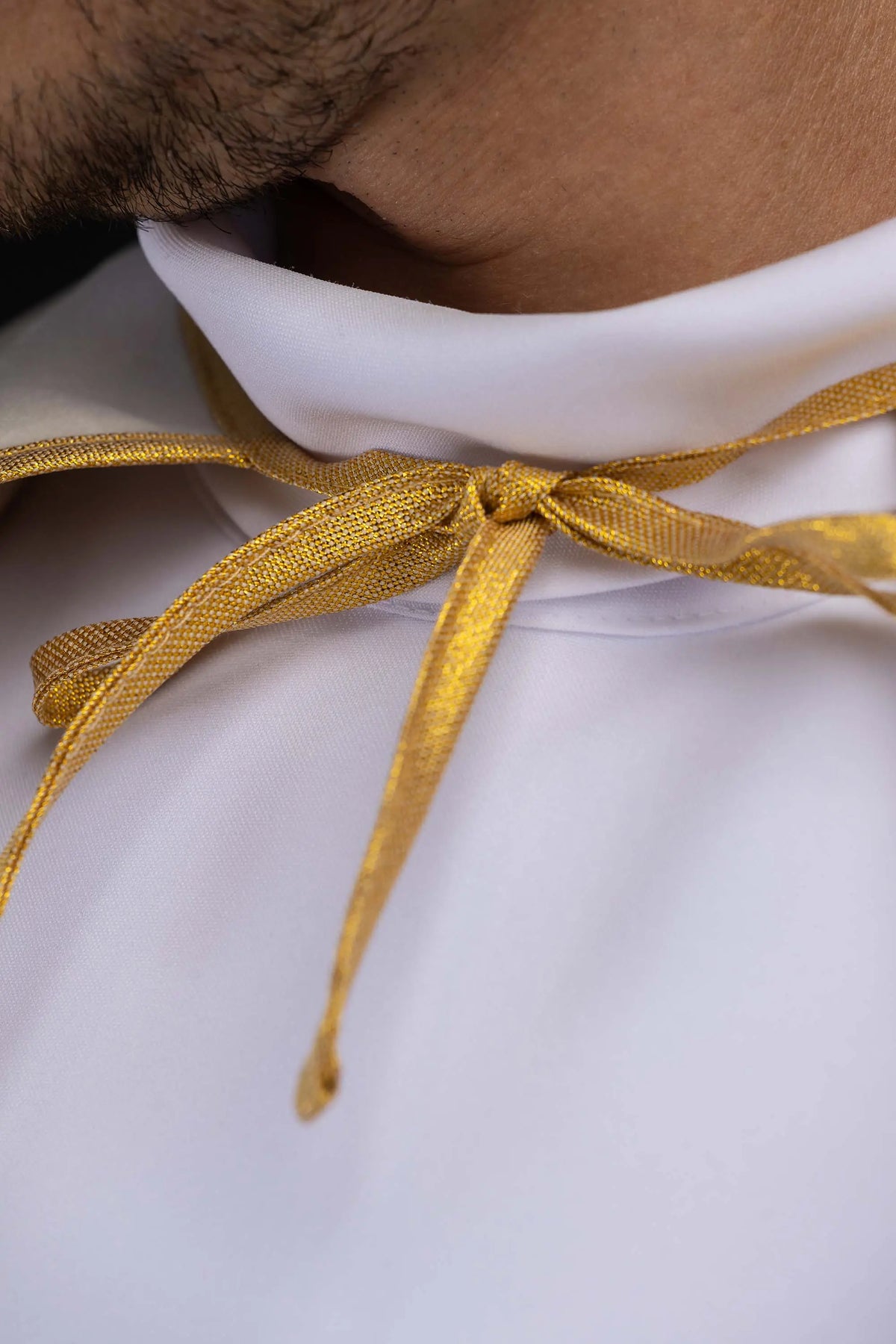 Écrue cape de servant d’autel en velours, lien doré noué au col, gros plan