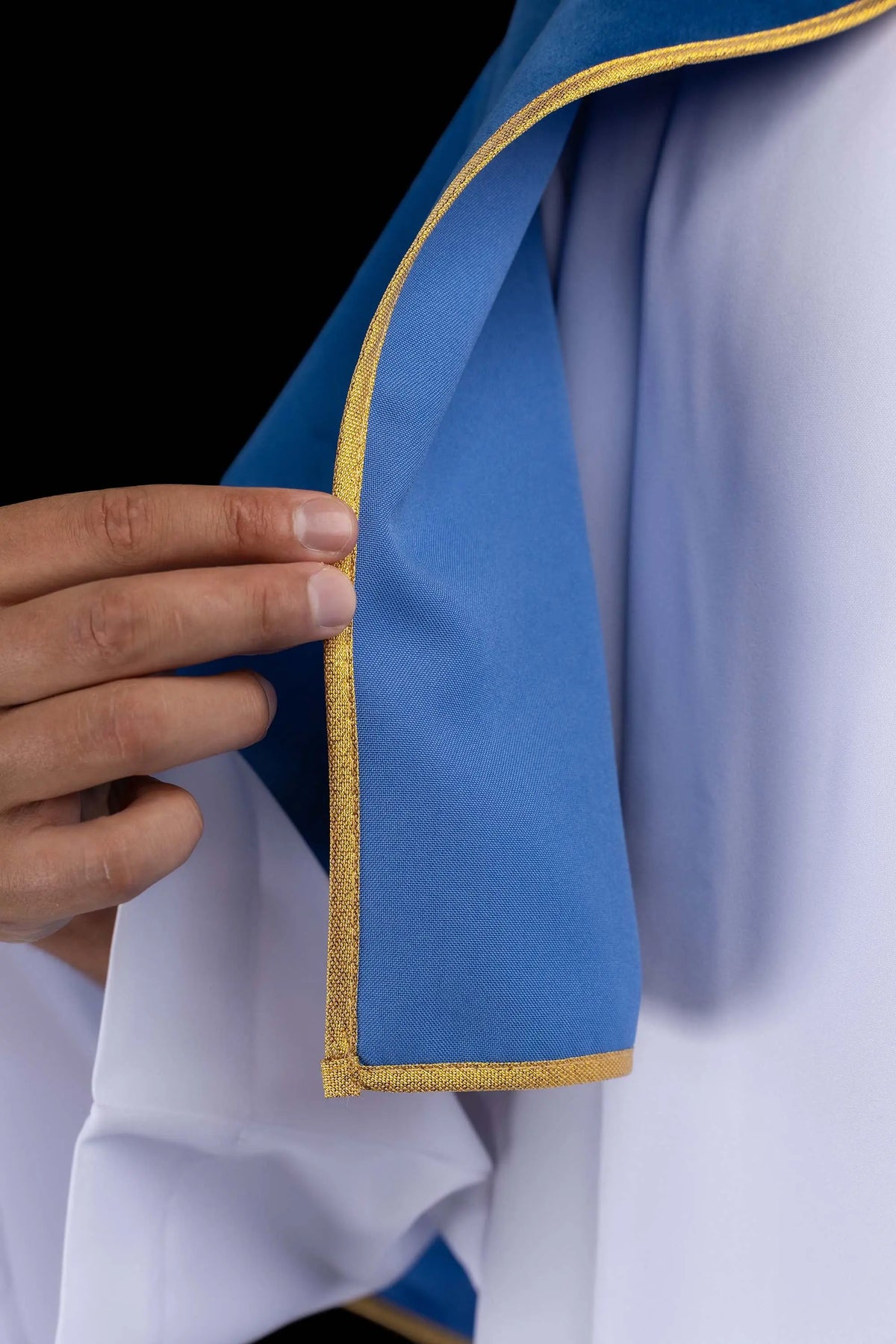 Bleue cape de servant d’autel en velours, gros plan du biais doré