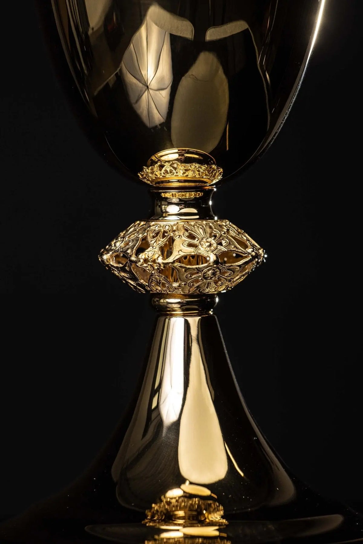 Doré calice avec ornement floral ajouré, détail rapproché de la coupe et du nœud