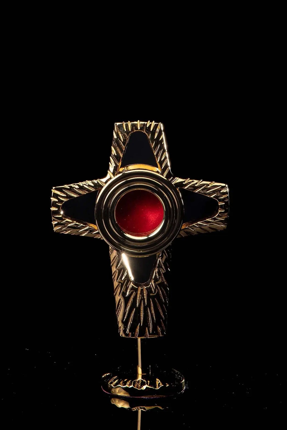 Doré reliquaire en forme de croix en laiton, ouverture circulaire rouge et rayons gravés, vue de face