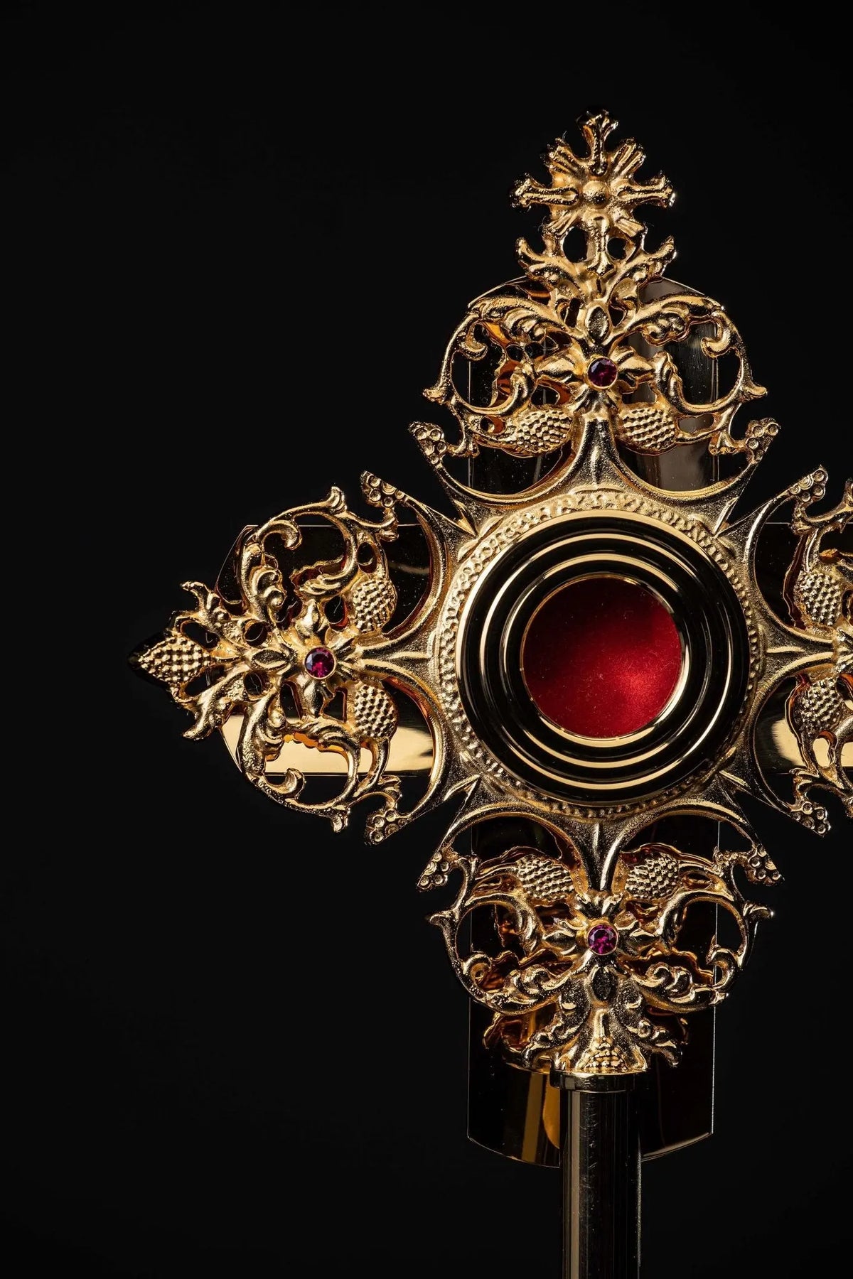 Doré reliquaire en laiton avec ornements floraux et cabochon rouge, gros plan de face