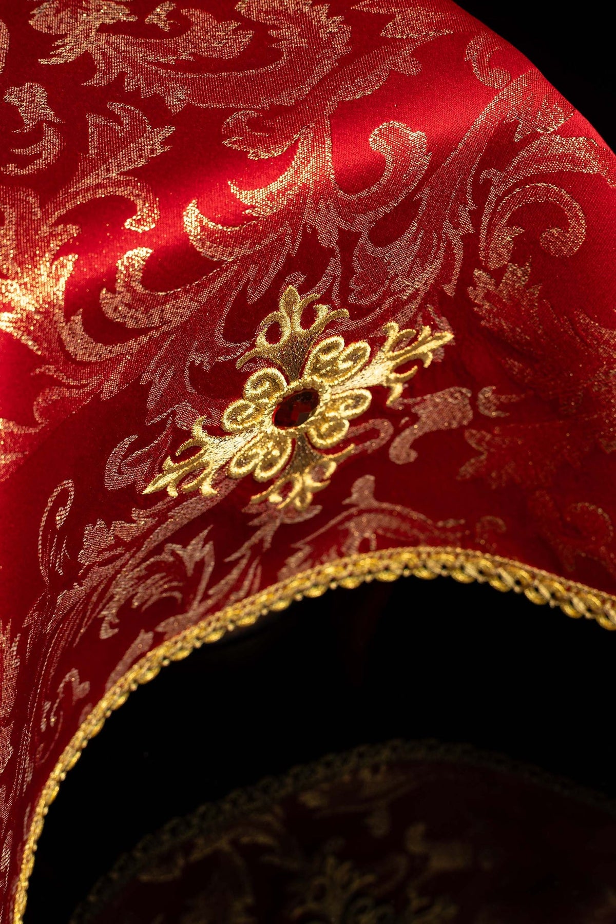Rouge voile de calice avec croix brodée et pierre décorative, vue rapprochée