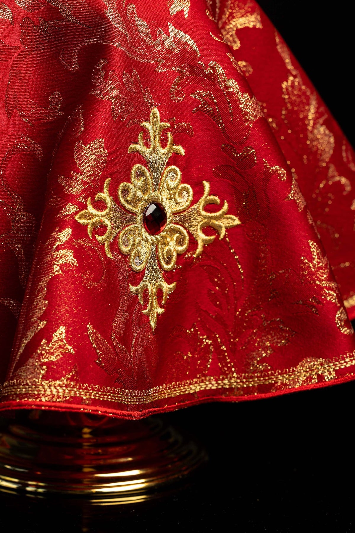 Rouge voile de ciboire brodé d'une croix dorée, gros plan de la bordure
