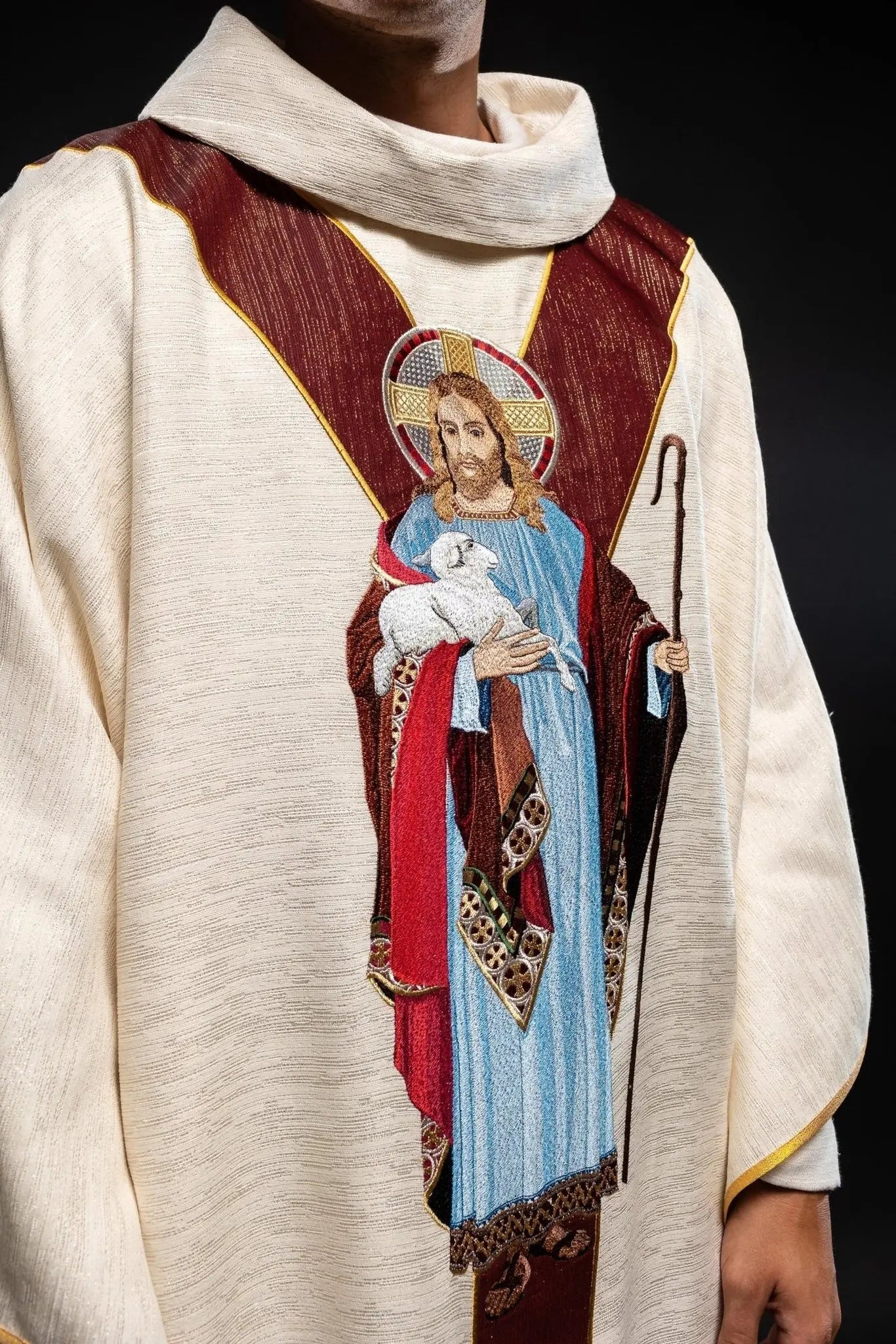 Chasuble écrue avec l'image de Jésus le Bon Pasteur avec une bande décorative bordeaux