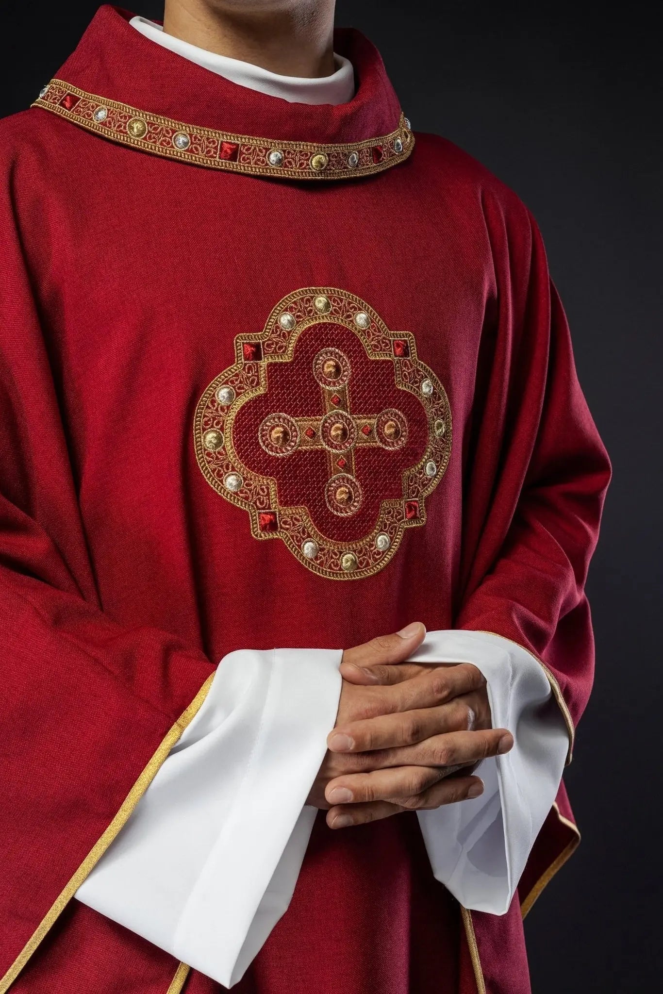 Chasuble rouge avec passepoil brodé sur le col et autour de la broderie de la croix