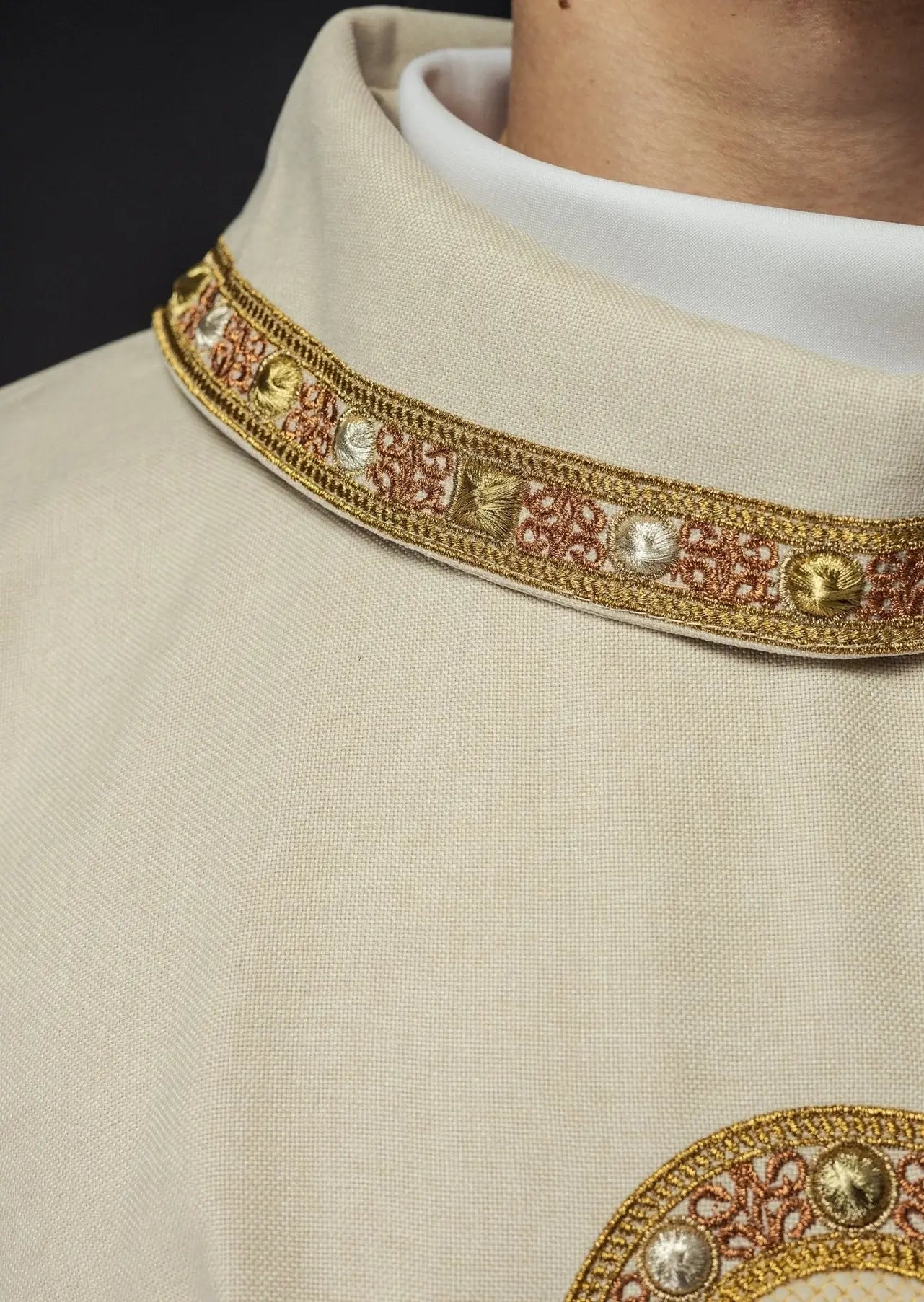 Chasuble in ecru color with embroidered trim on the collar and around the embroidery of the cross