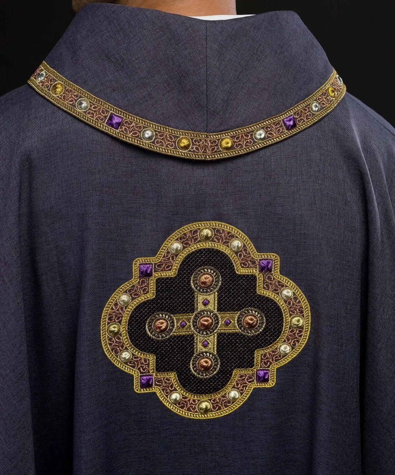Chasuble violette avec passepoil brodé sur le col et autour de la broderie de la croix