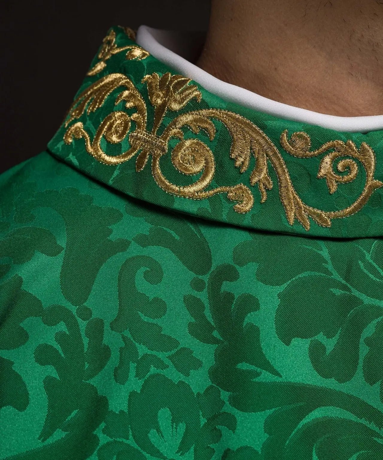 Chasuble verte avec motif IHS et col richement brodé sur tissu décoratif