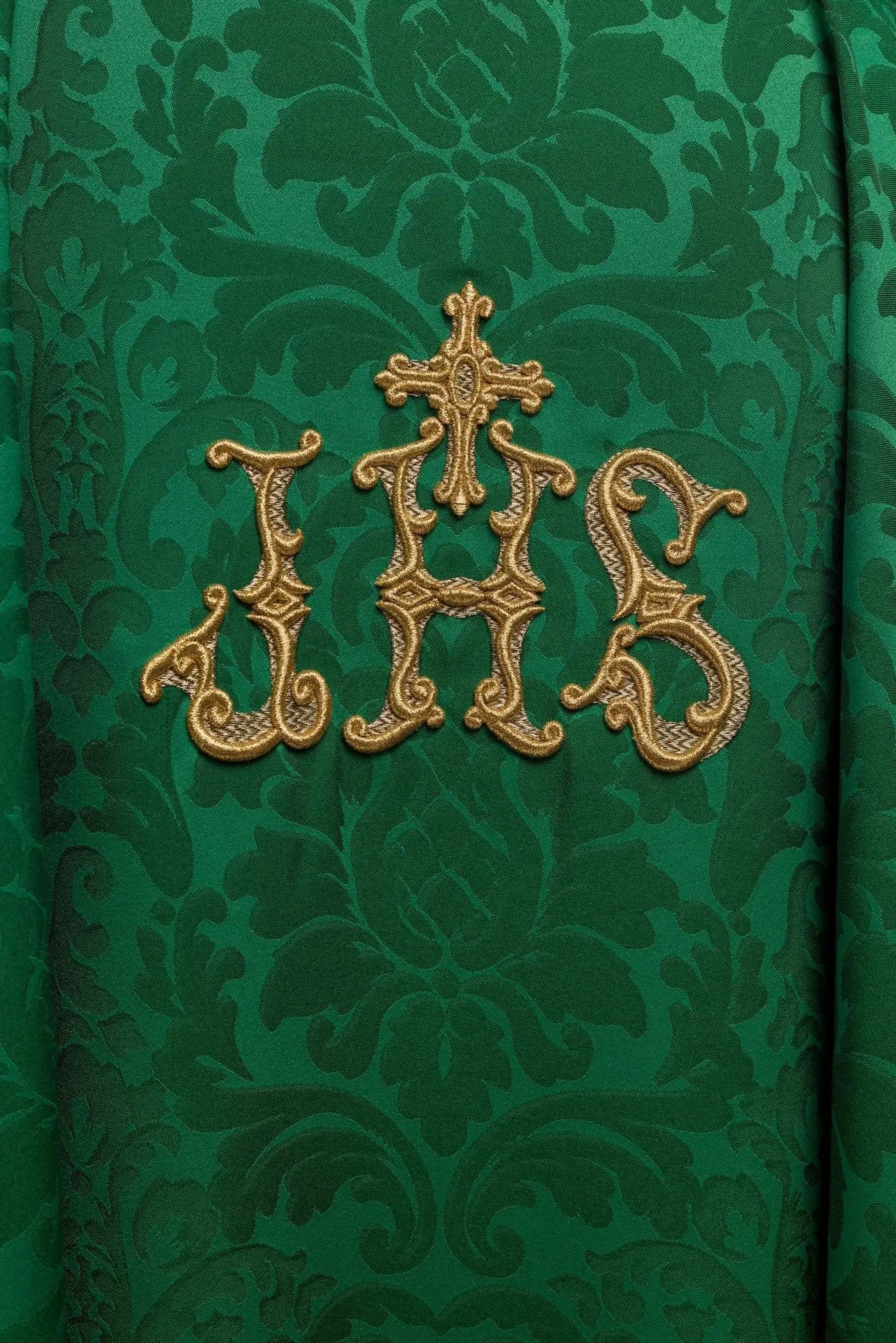 Chasuble verte avec motif IHS et col richement brodé sur tissu décoratif