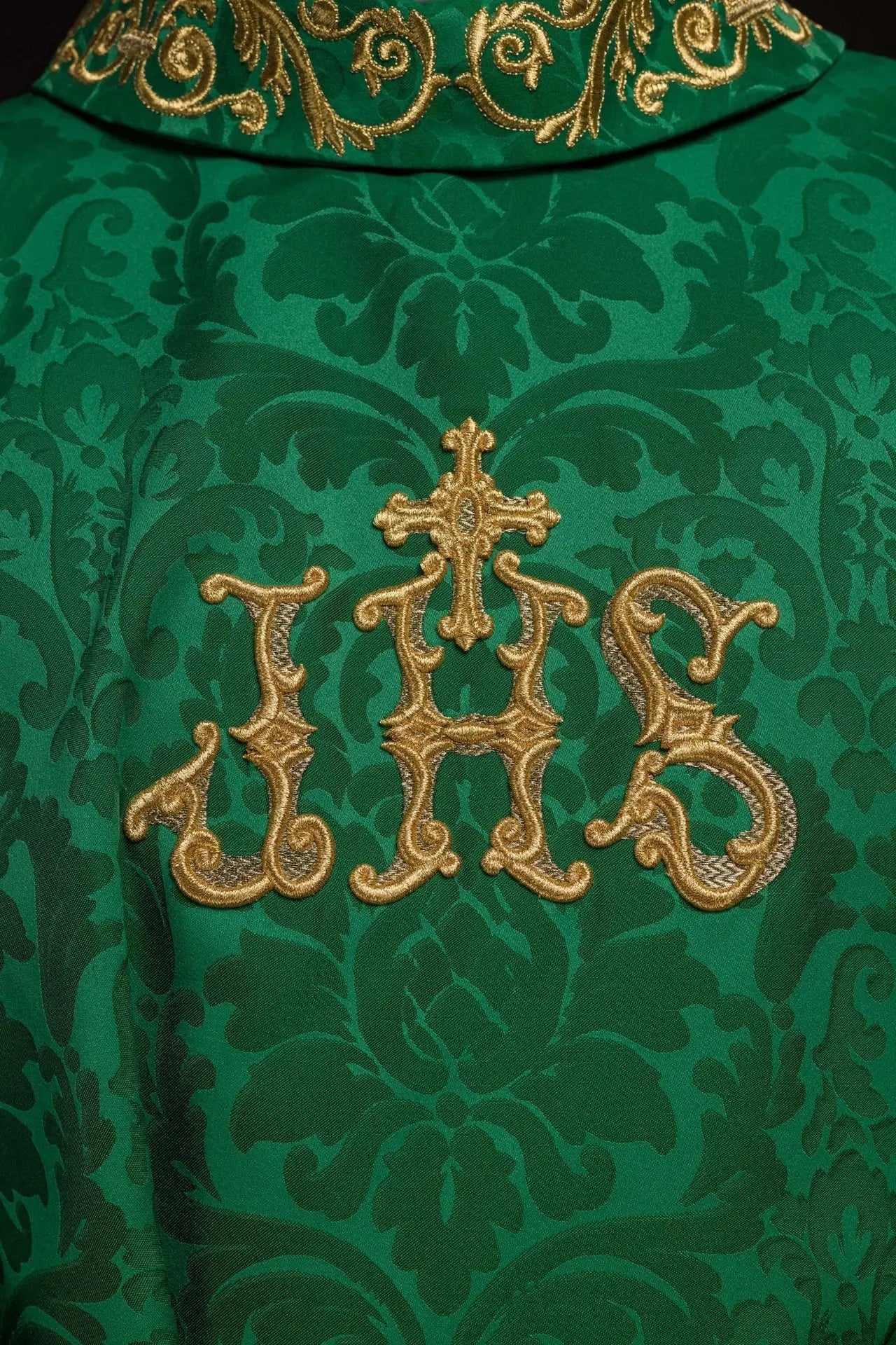 Chasuble verte avec motif IHS et col richement brodé sur tissu décoratif