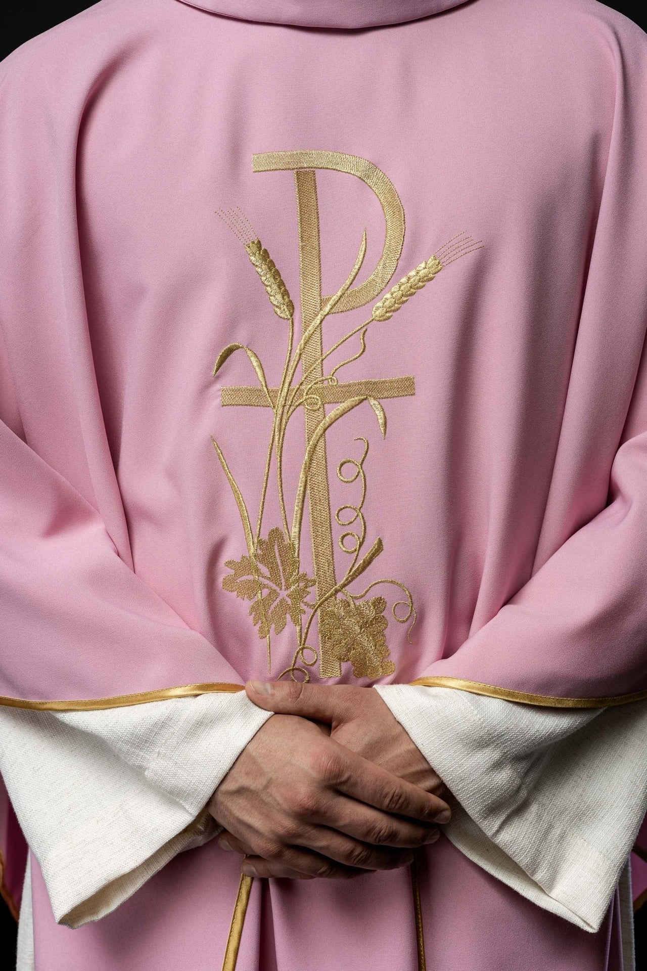 Różowy ornat z złotym haftem krzyża
