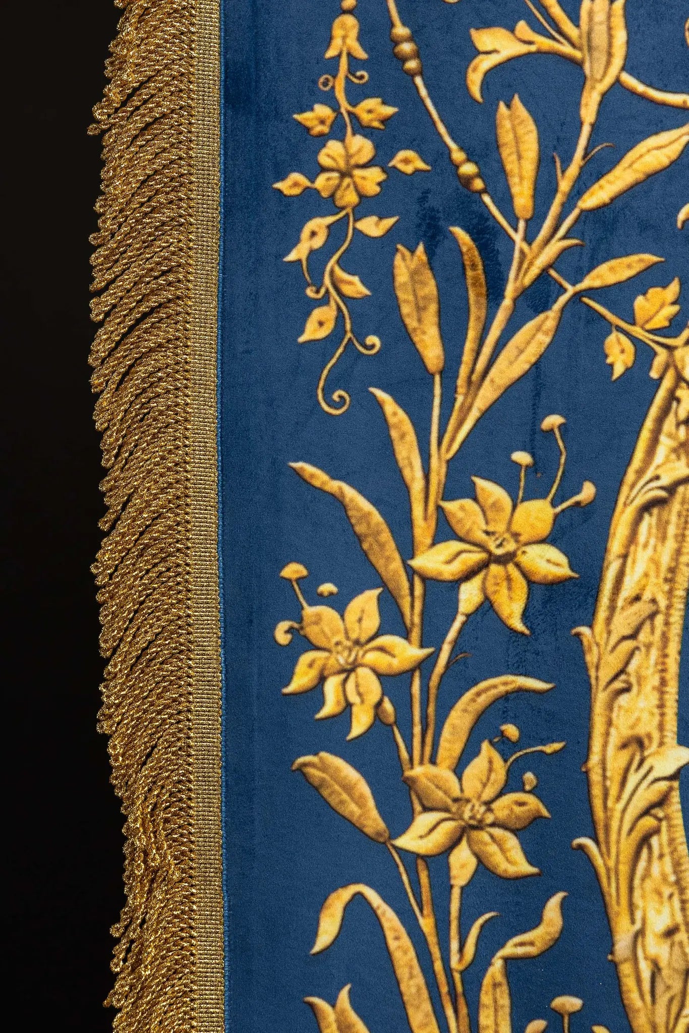 Double-sided blue processional banner with an image of Our Lady of the Immaculate Conception on one side and a Marian monogram on the other, both surrounded by gold floral ornamentation and finished with gold fringes.