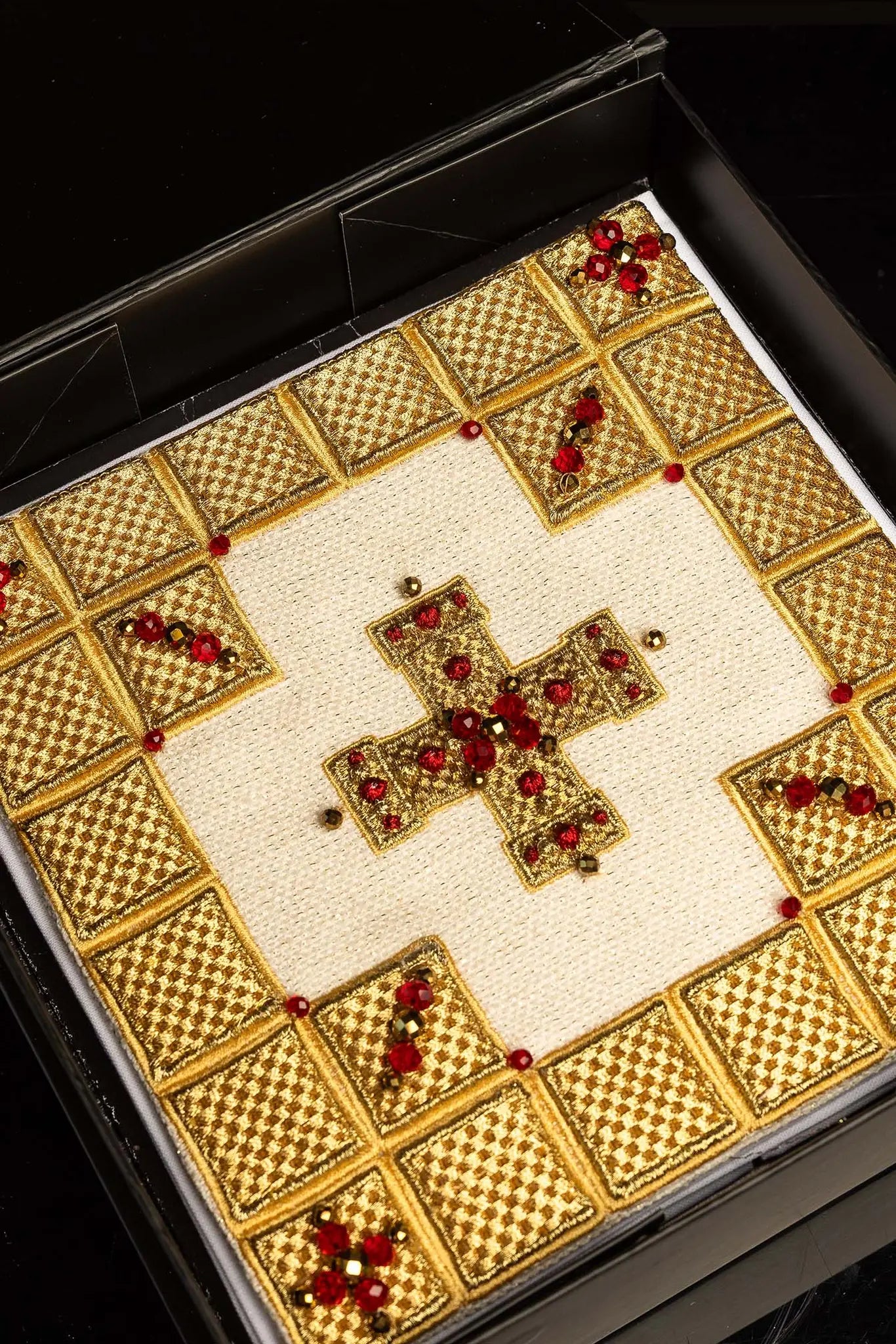 Ecru handmade chalice linen set with a pall featuring a dimensional gold cross, red hematite, and shimmering crystals, a corporal with a central cross, and a purificator and lavabo towel with embroidered crosses, all with scalloped edges.