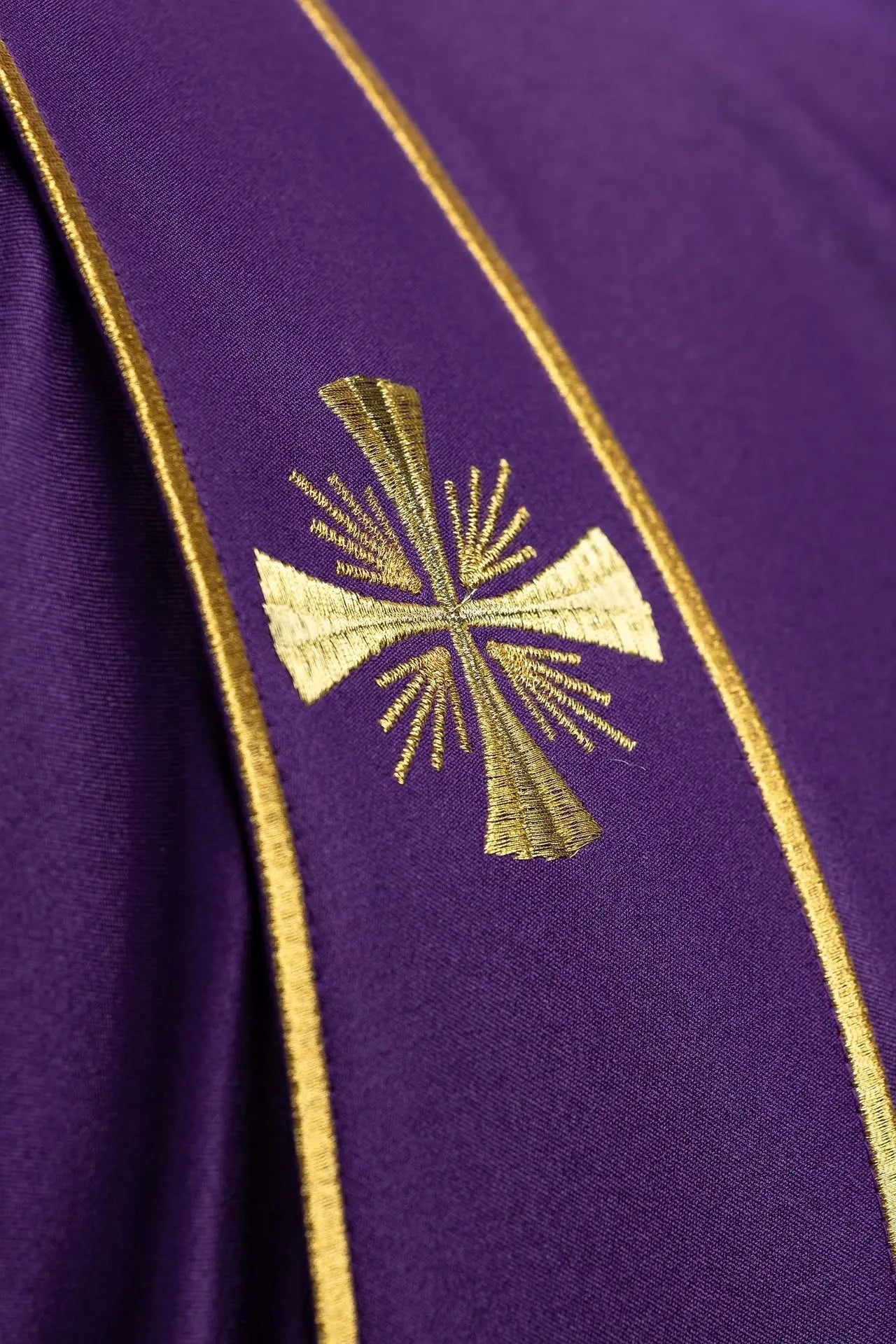 Dalmatique violette avec bandes décoratives et broderie de croix dorée