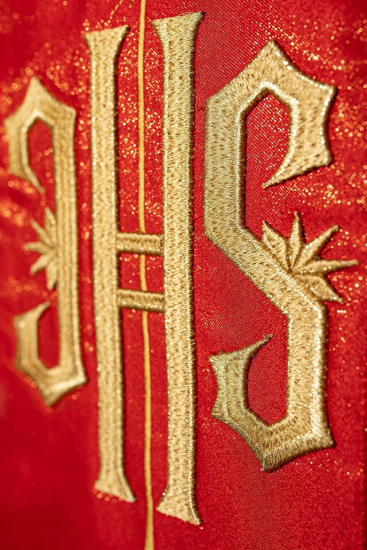 Chasuble rouge richement décorée d'un motif doré et d'une large bande IHS