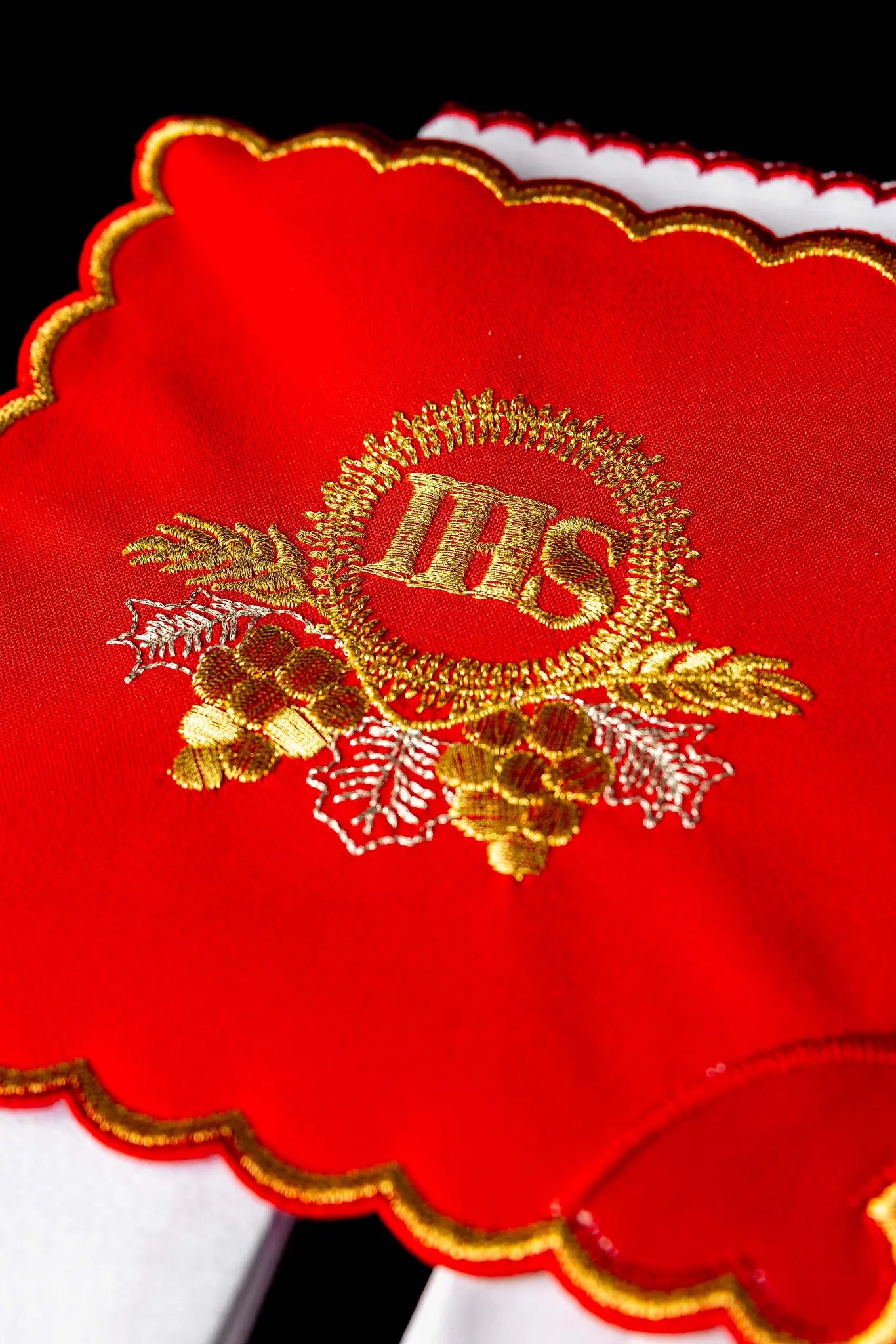 Red chalice linen set with gold IHS embroidery, including a red pall, white corporal, white purificator, and white lavabo towel, all with matching gold IHS symbols and scalloped embroidered edges.