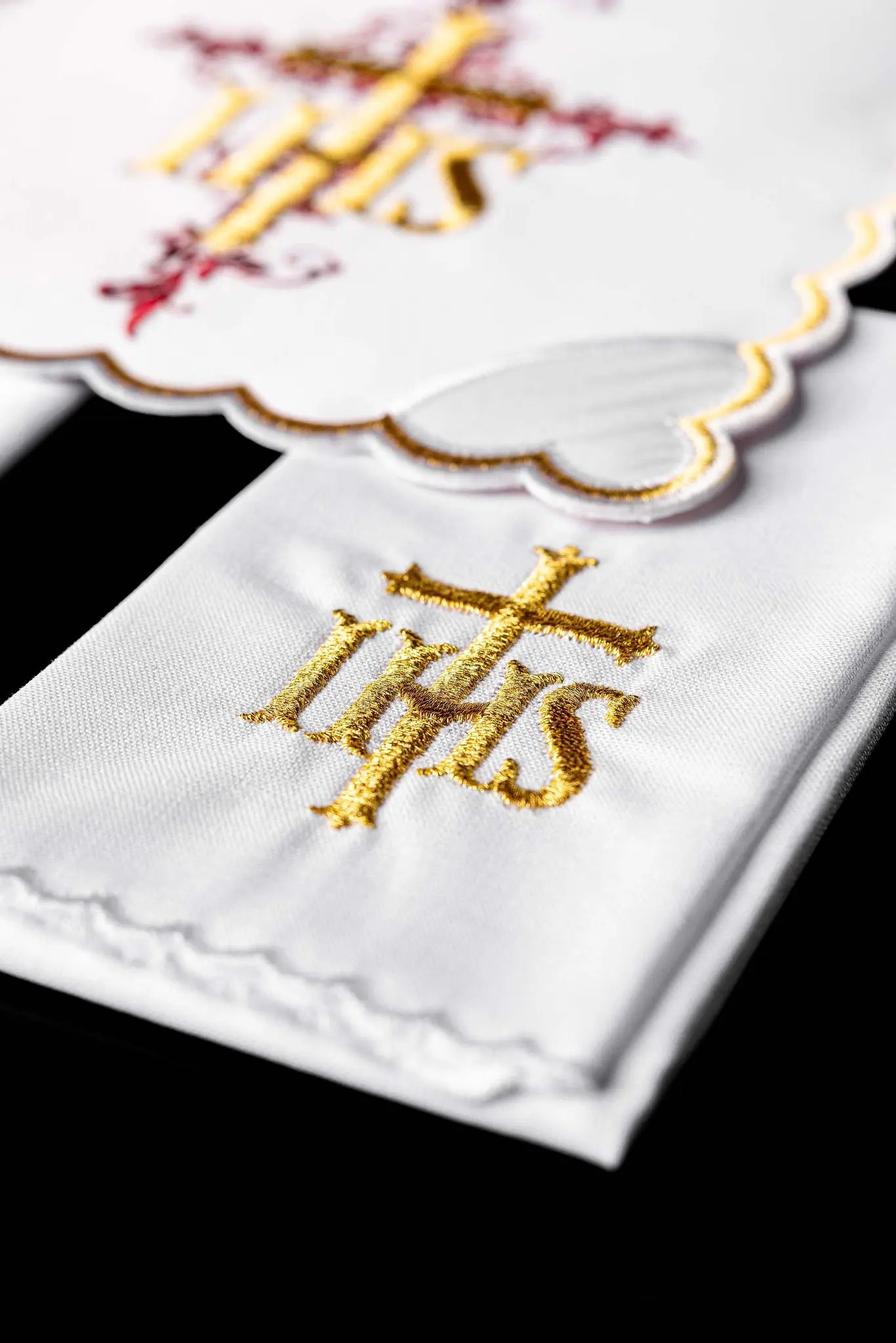 White chalice linen set with IHS embroidery, including pall, corporal, purificator, and lavabo towel.