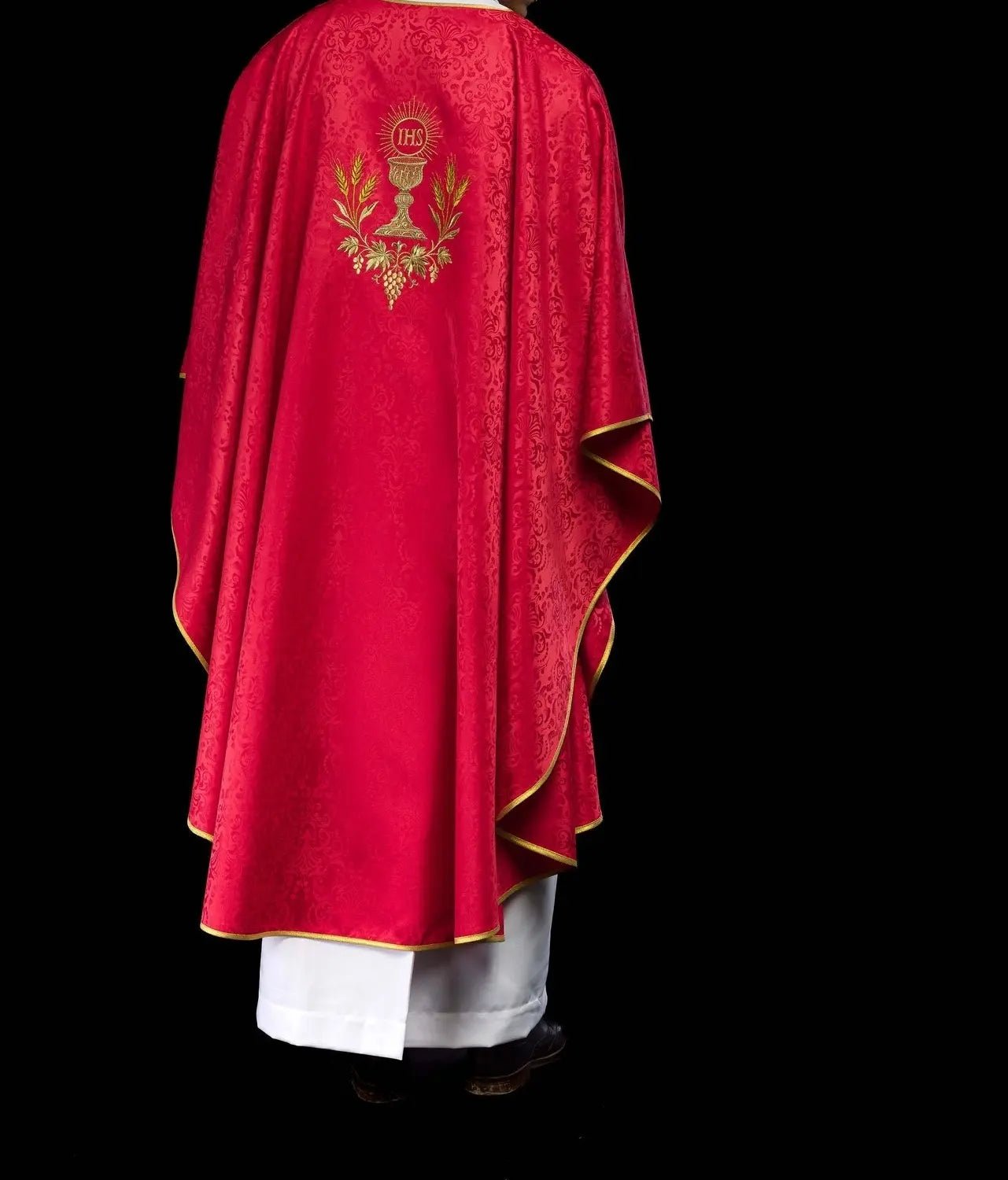 Chasuble liturgique rouge avec un calice brodé et une hostie sur tissu jacquard