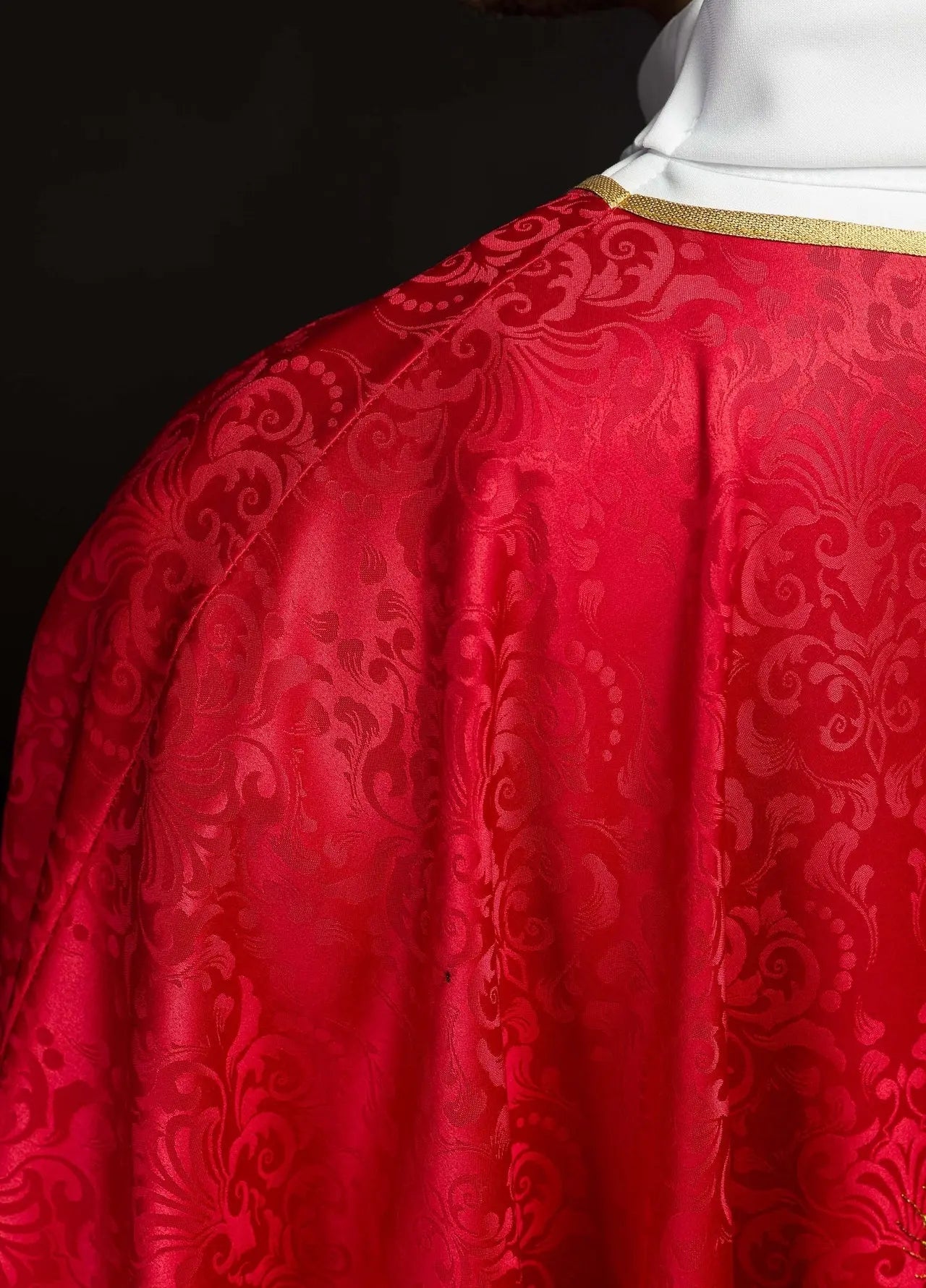 Chasuble liturgique rouge avec un calice brodé et une hostie sur tissu jacquard