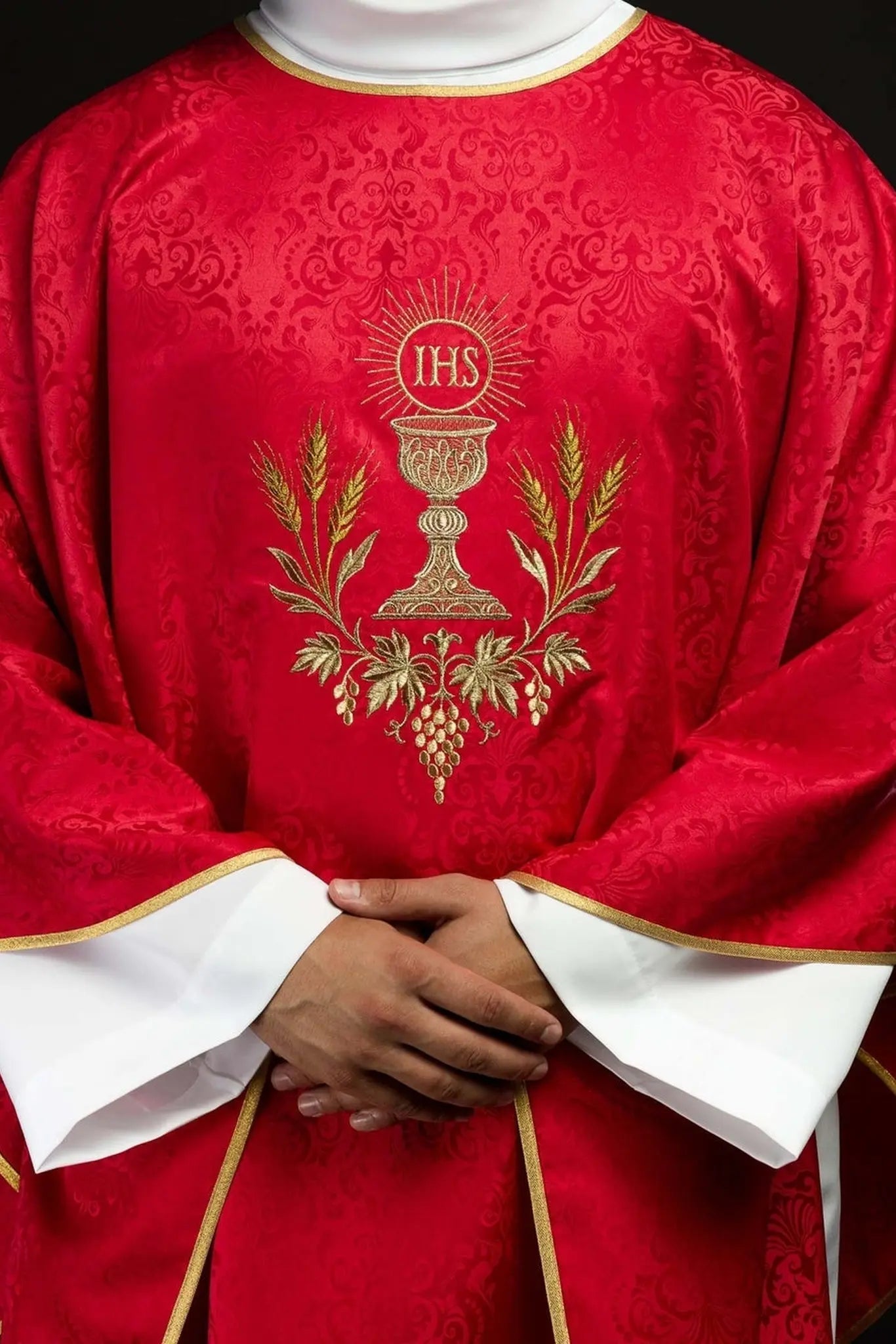 Chasuble liturgique rouge avec un calice brodé et une hostie sur tissu jacquard